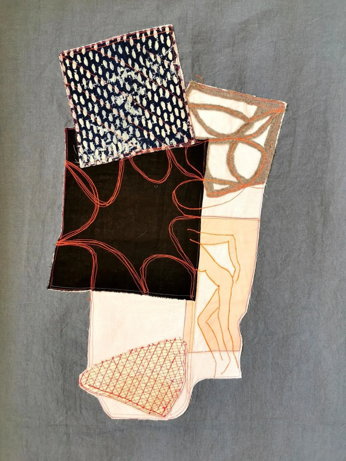 Mixed-material textile piece with patterned surfaces and thread-drawn figures, part of a contemporary textile art exhibition in Europe