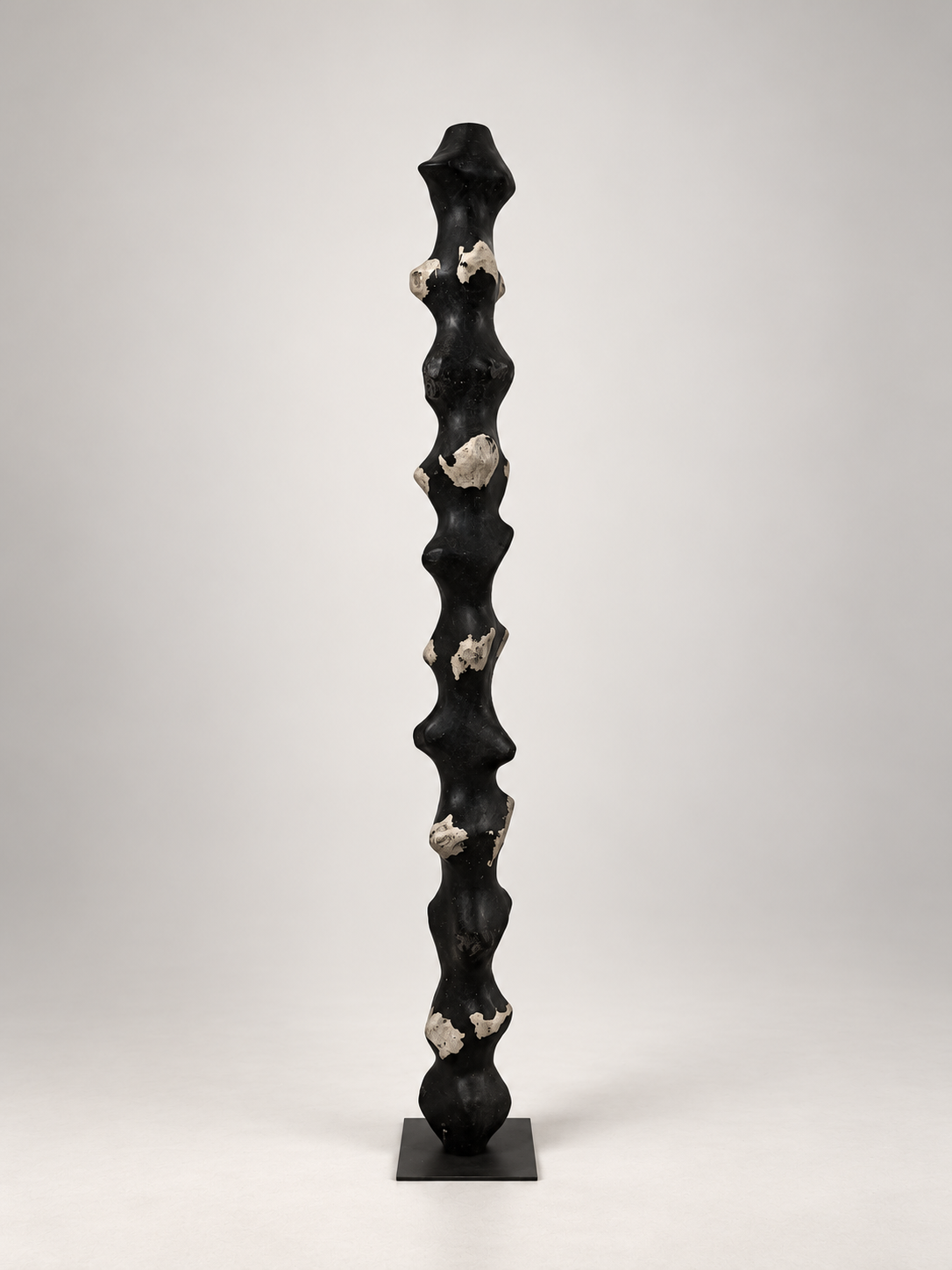 Tótem III by Justino Del Casar, tall black recycled paper sculpture with raw paper details on a metal base