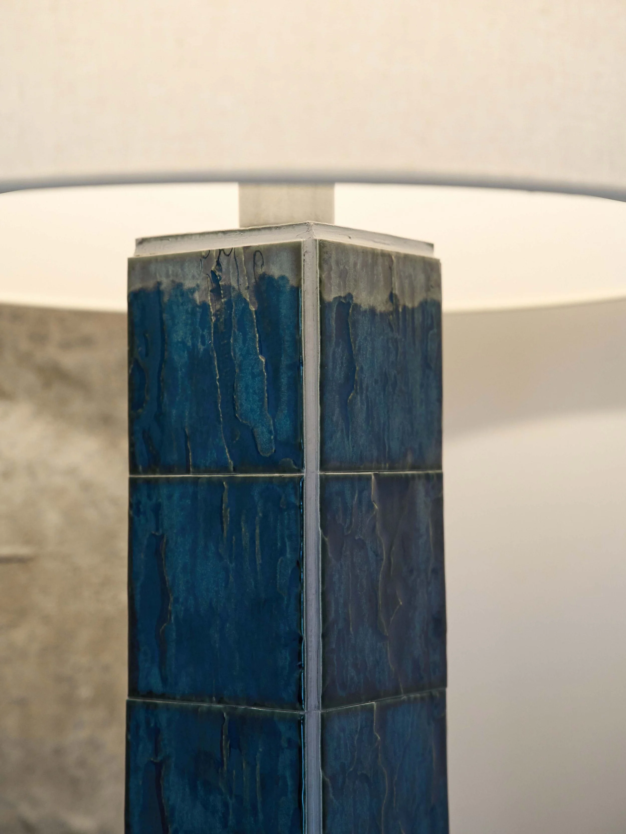 Contemporary floor lamp mixing artisanal tiles and soft textile illumination.