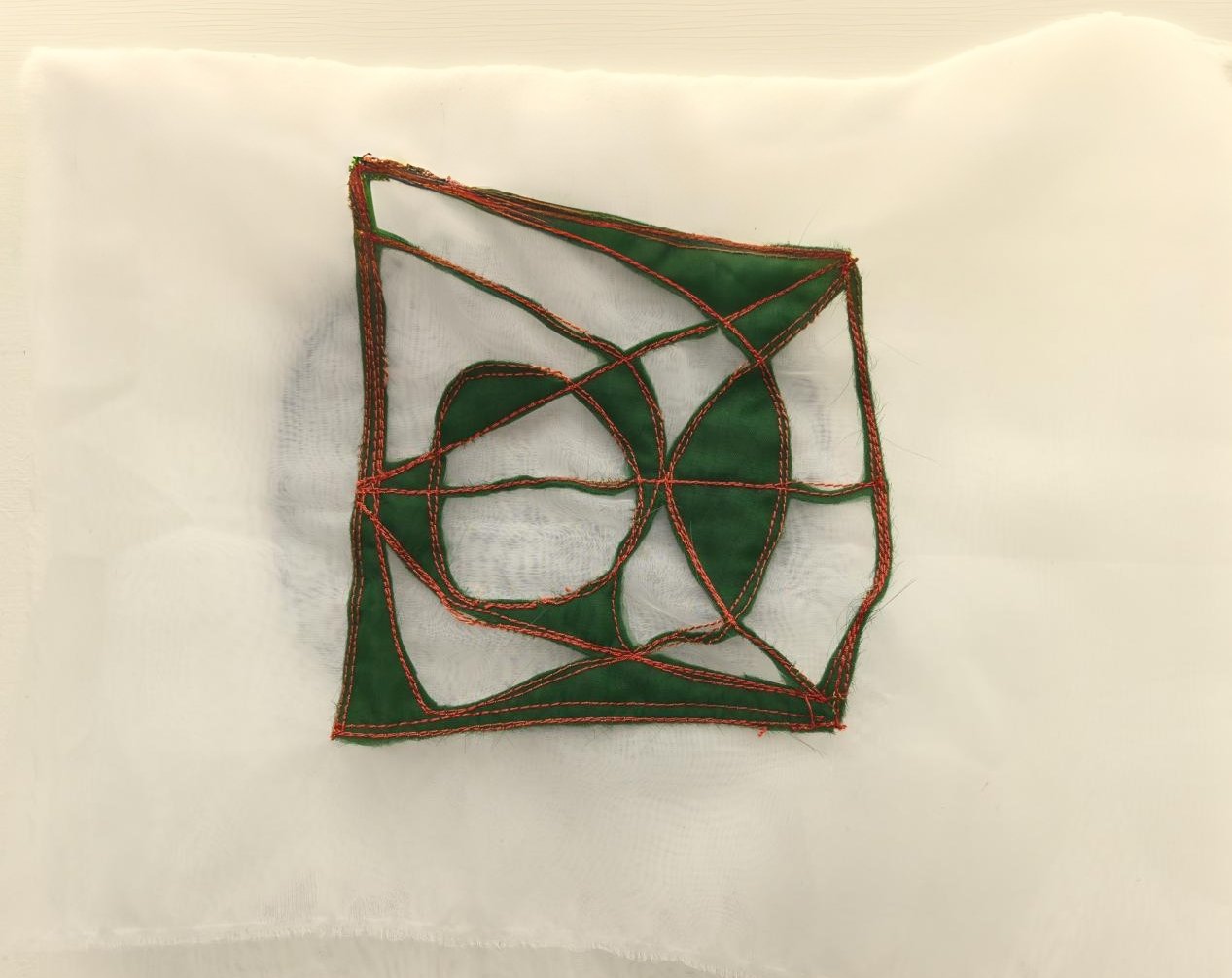 Handcrafted textile wall art combining fabric layering and expressive threadwork, part of a contemporary textile art showcase at EAST WEST SPACE