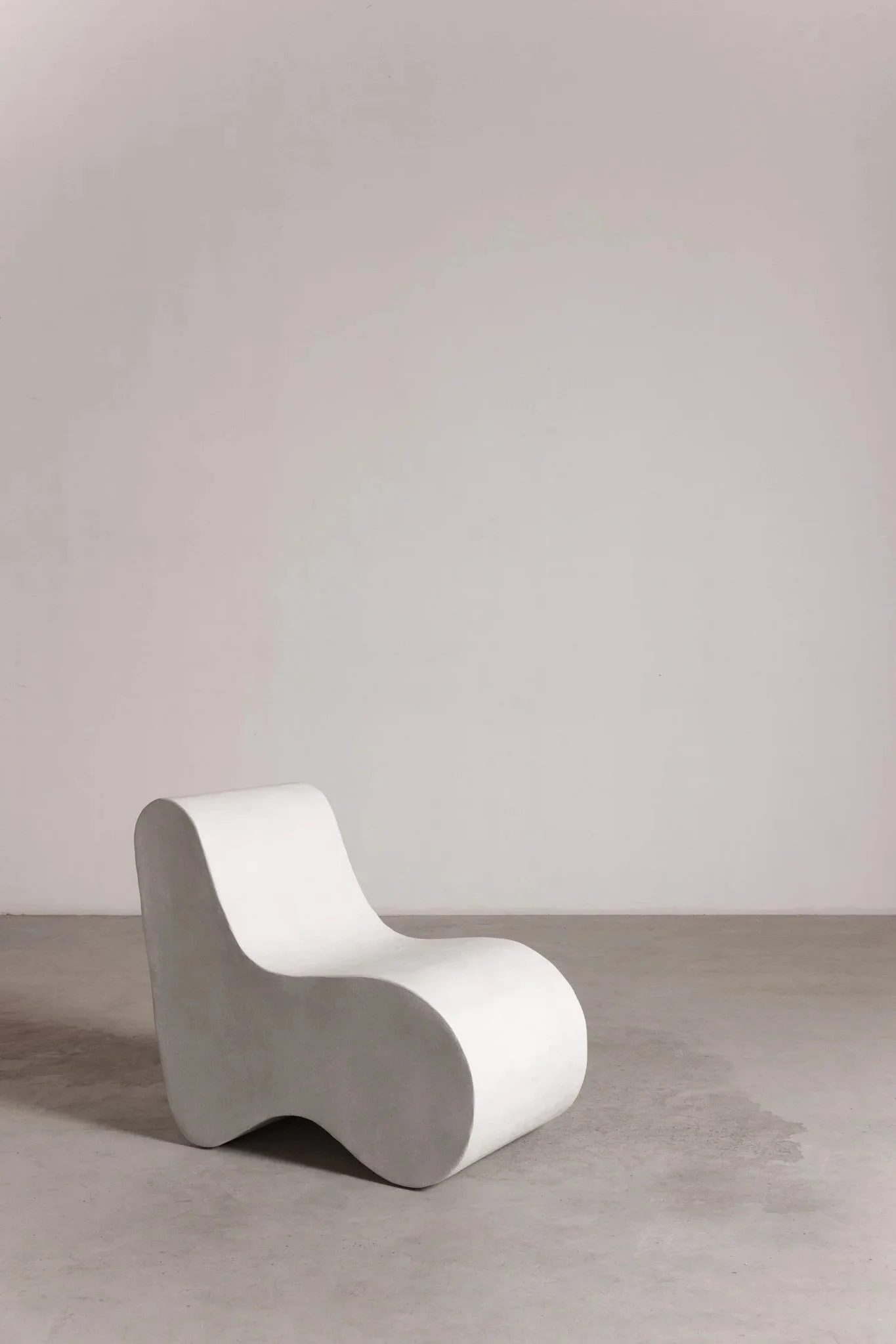 Three-quarter view of Nuage chair by ITS A MOOD, S-shaped biomorphic seat with a void at its base, BLANCONEGRO BARCELONA