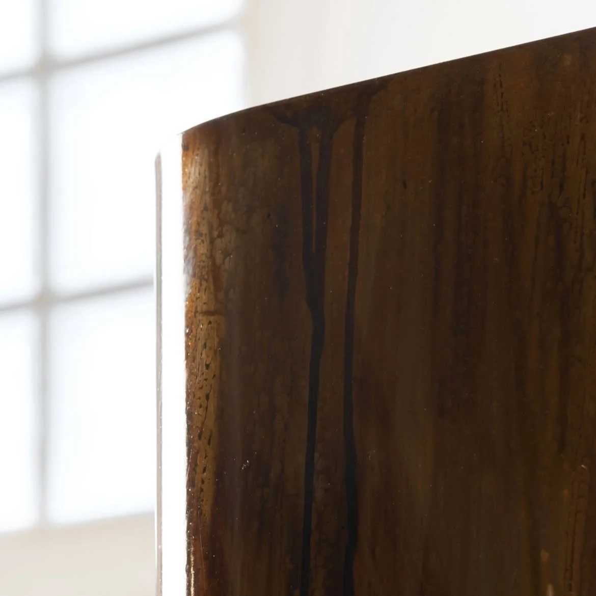 Minimal sculptural lamp featuring warm uplight and downlight between curved metal elements.