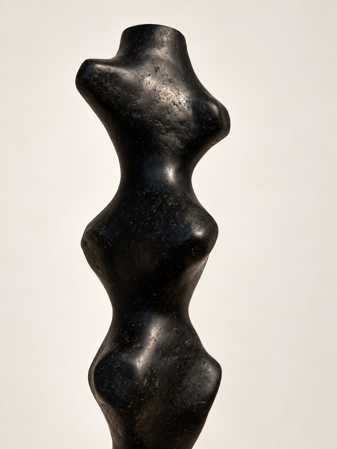 Close-up of the top of Tótem II by Justino Del Casar, smooth biomorphic curves in matte black recycled paper