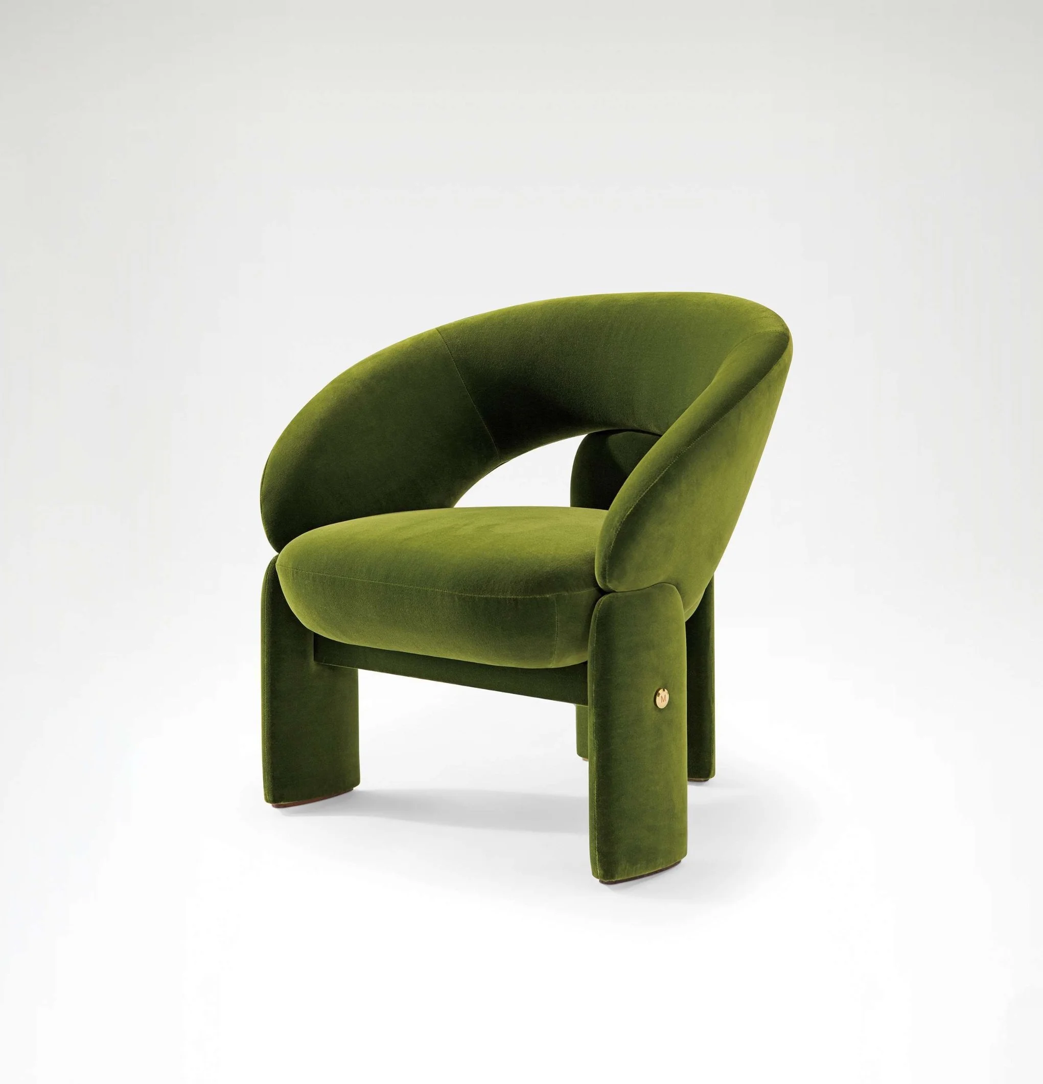 Sculptural velvet armchair featuring three-legged design and soft organic curves.