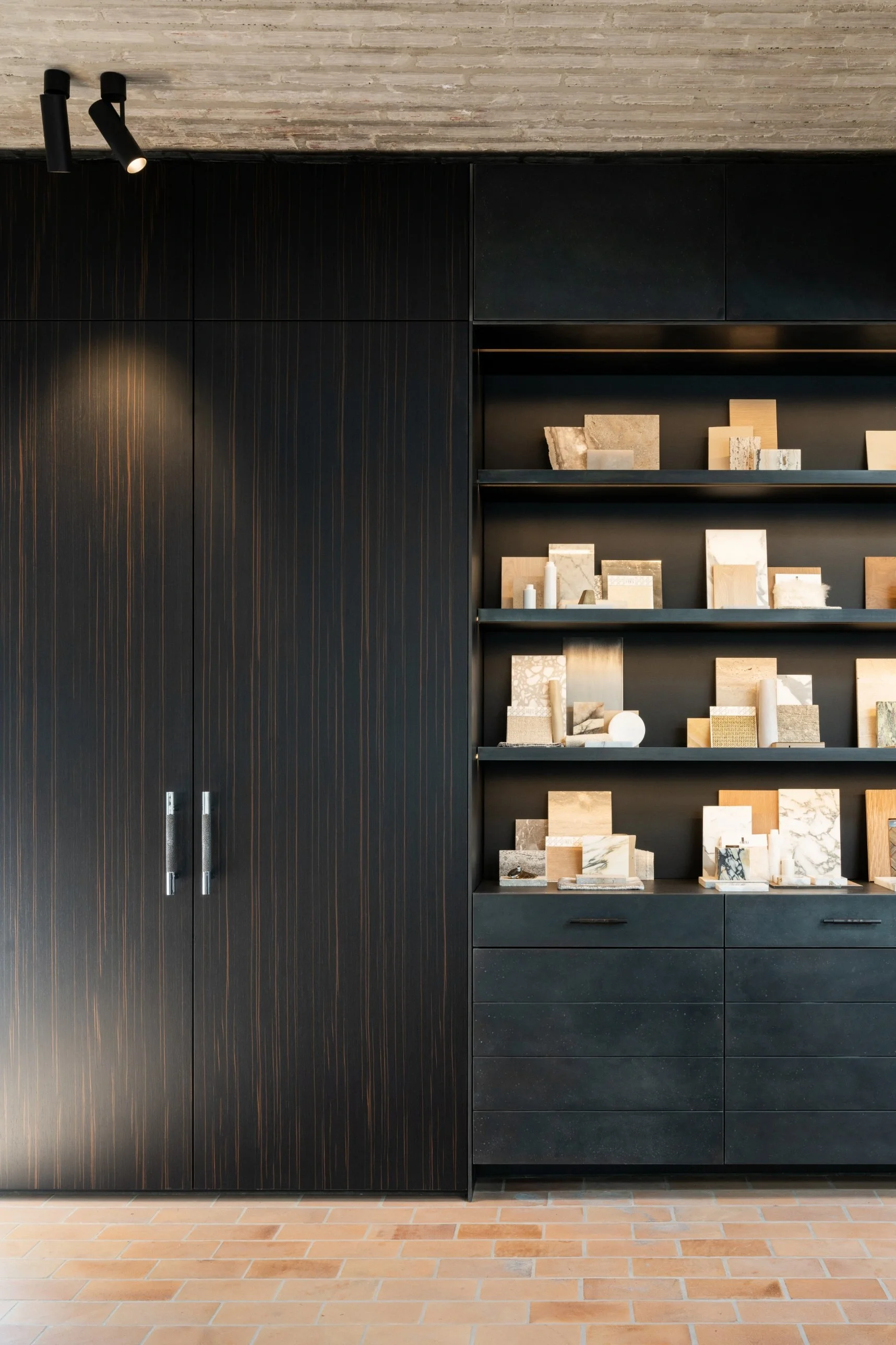 Black Kreon Holon 60 Directional Surface spotlights lighting dark wood cabinetry and a material sample library