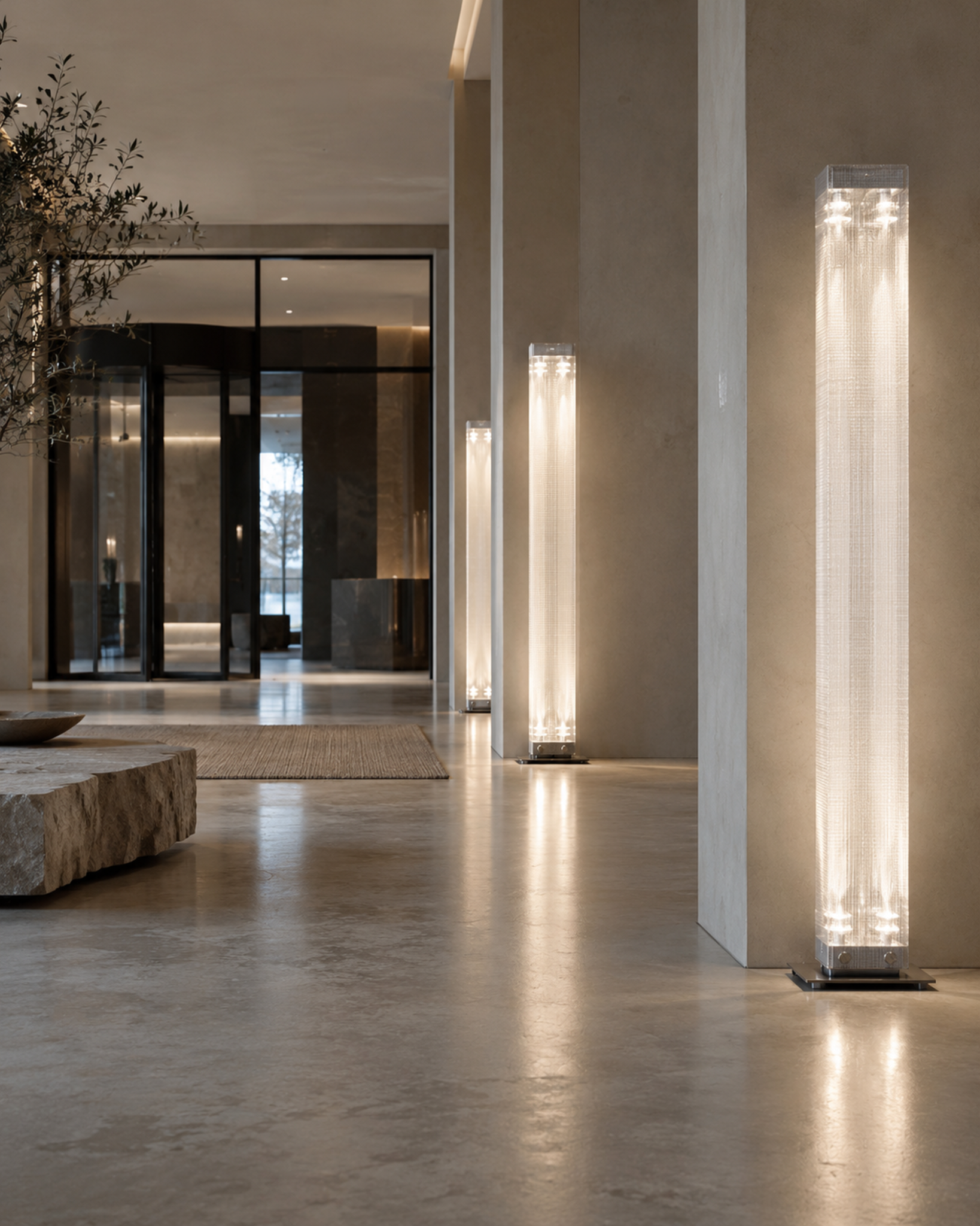 Row of Belux Twilight floor lamps in stainless steel lighting the columns of an elegant hotel lobby