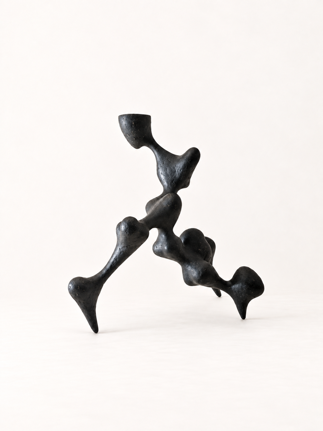 Bicho II black recycled paper sculpture by Justino Del Casar, angled view showing its organic, jointed limbs