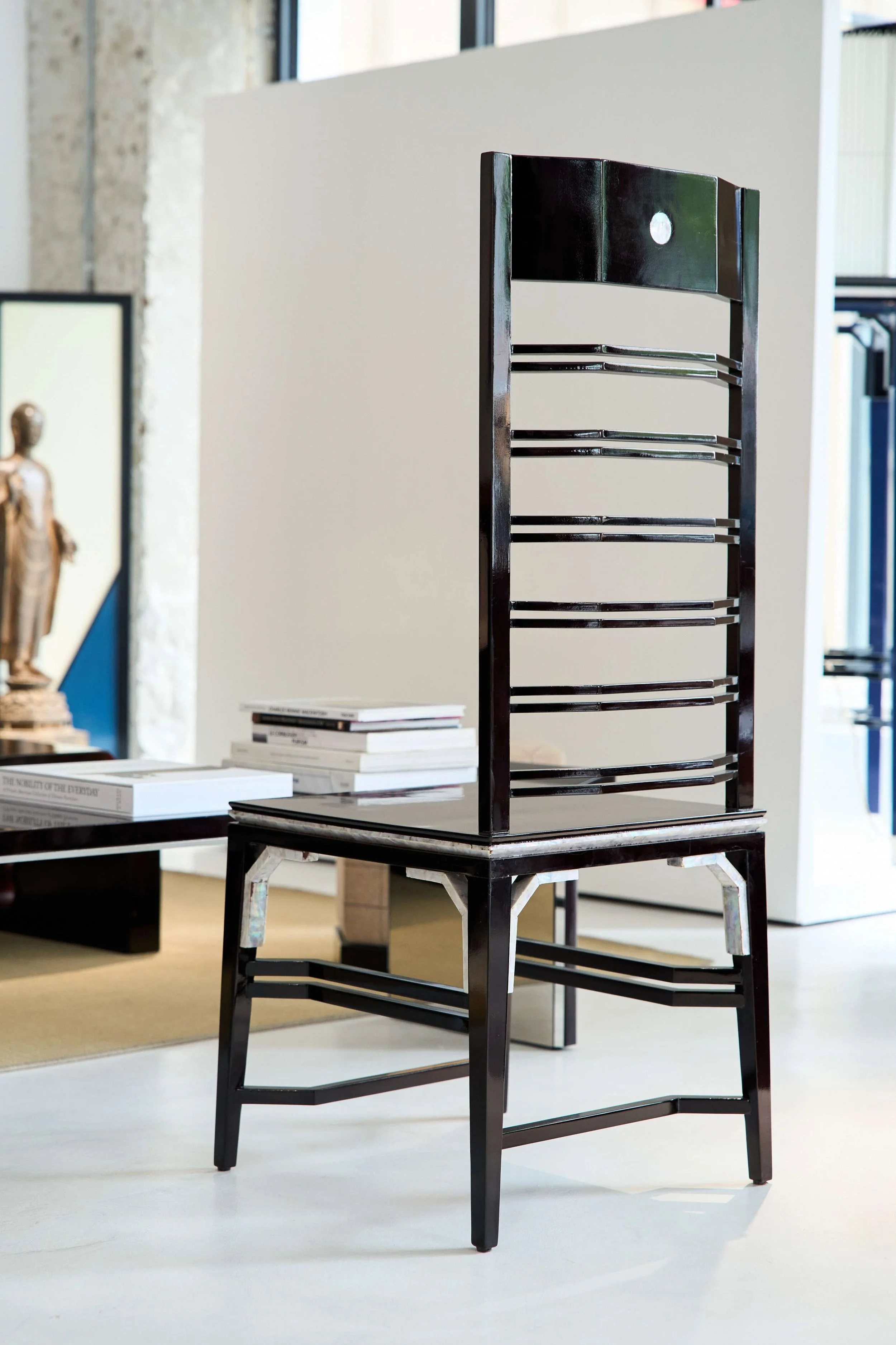 Black sculptural chair with vertical backrest inspired by traditional Chinese design.