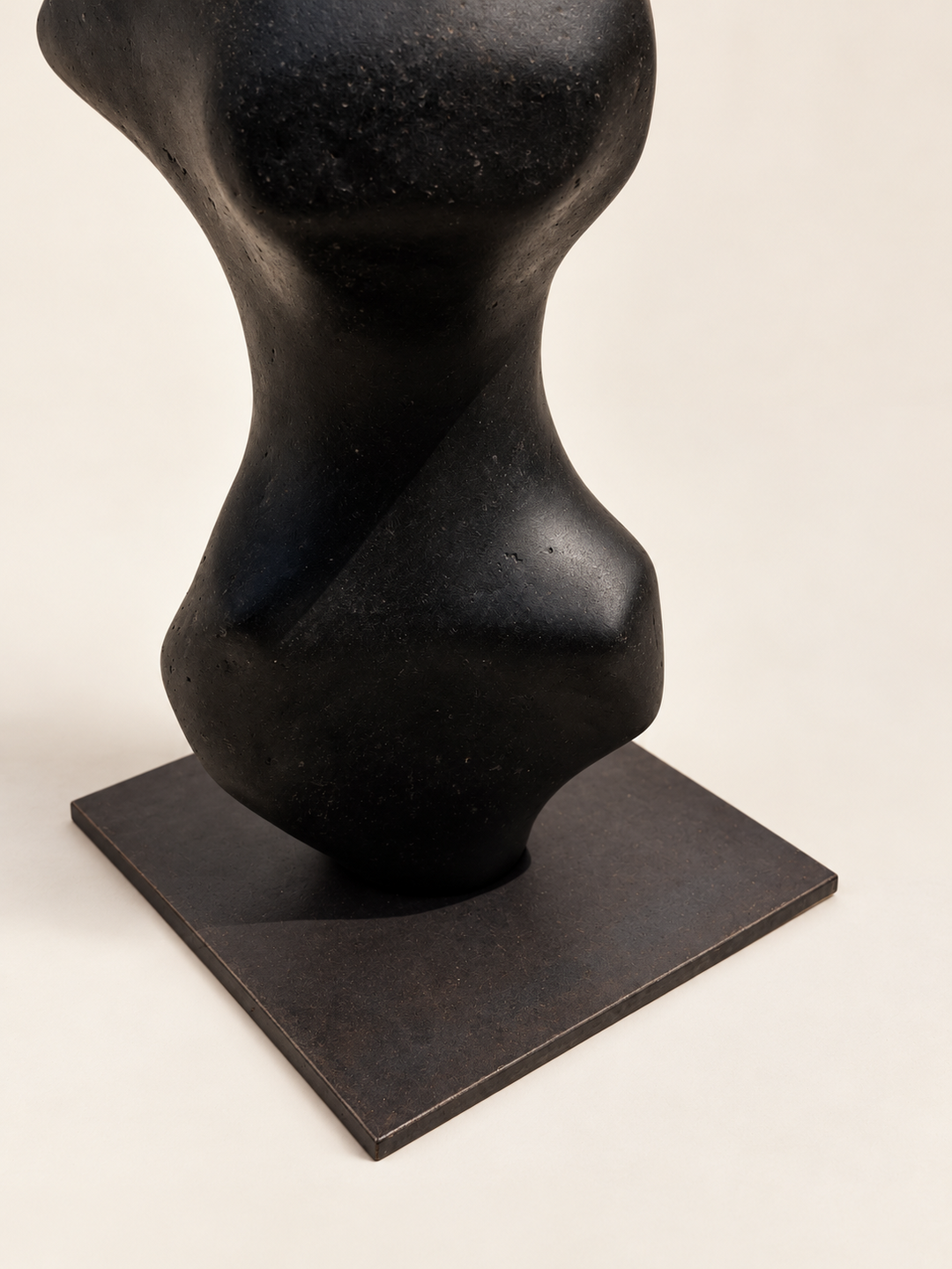 Base of Tótem I by Justino Del Casar, black recycled paper sculpture resting on a square metal plinth