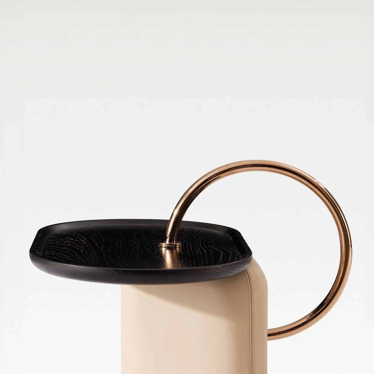 Luxury designer table blending leather, solid wood and metal ring element.