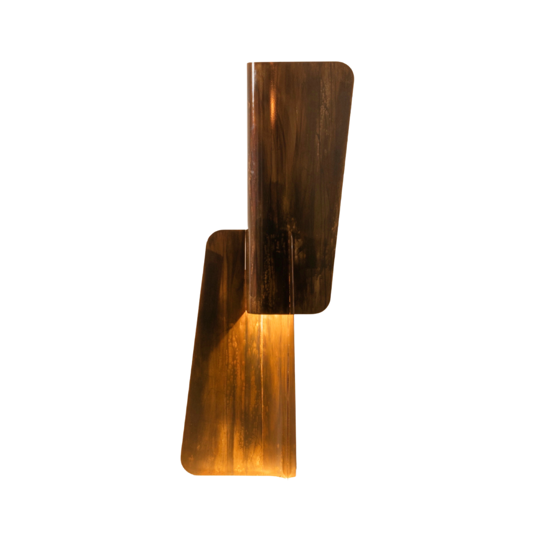 Modern architectural floor lamp with folded metal volumes emitting warm ambient light, Maxime Halot design.