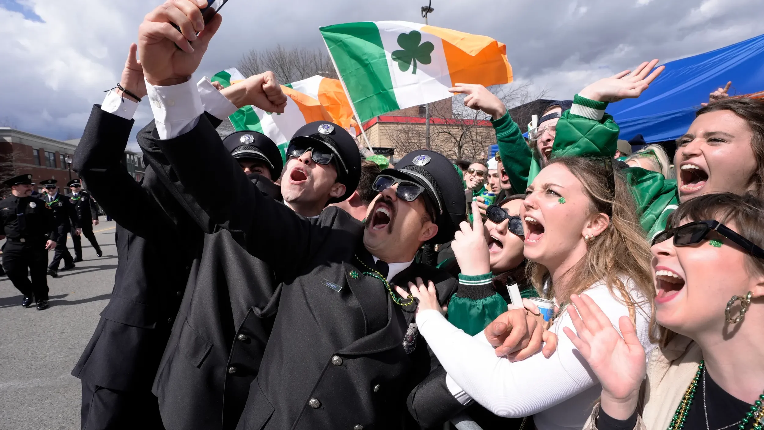 A group of firemen from around the United States pose for a selfie with spectators while marching in the St. Patrick’s Day parade, Sunday, March 17, 2024, in Boston’s South Boston neighborhood.