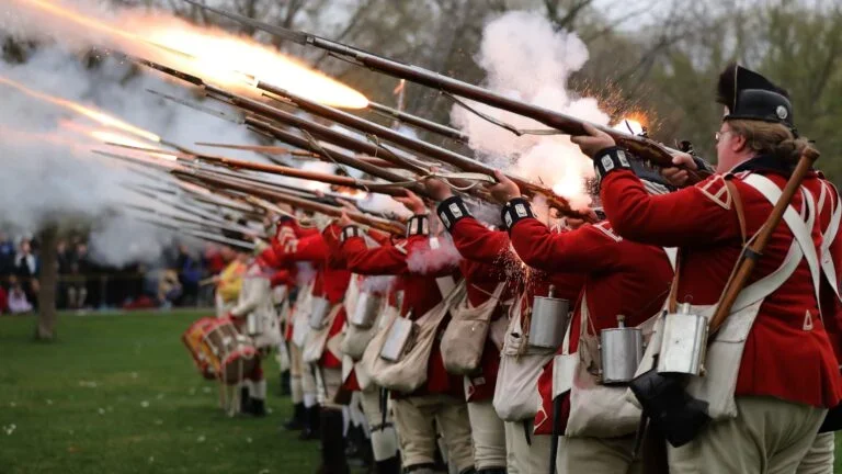The British Regulars fired their muskets during the re­enactment of the Battle of Lexington on the town green in April 2023. 