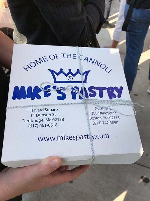 The iconic white and blue pastry box from Mike's Pastry, a famous bakery known for its cannolis.