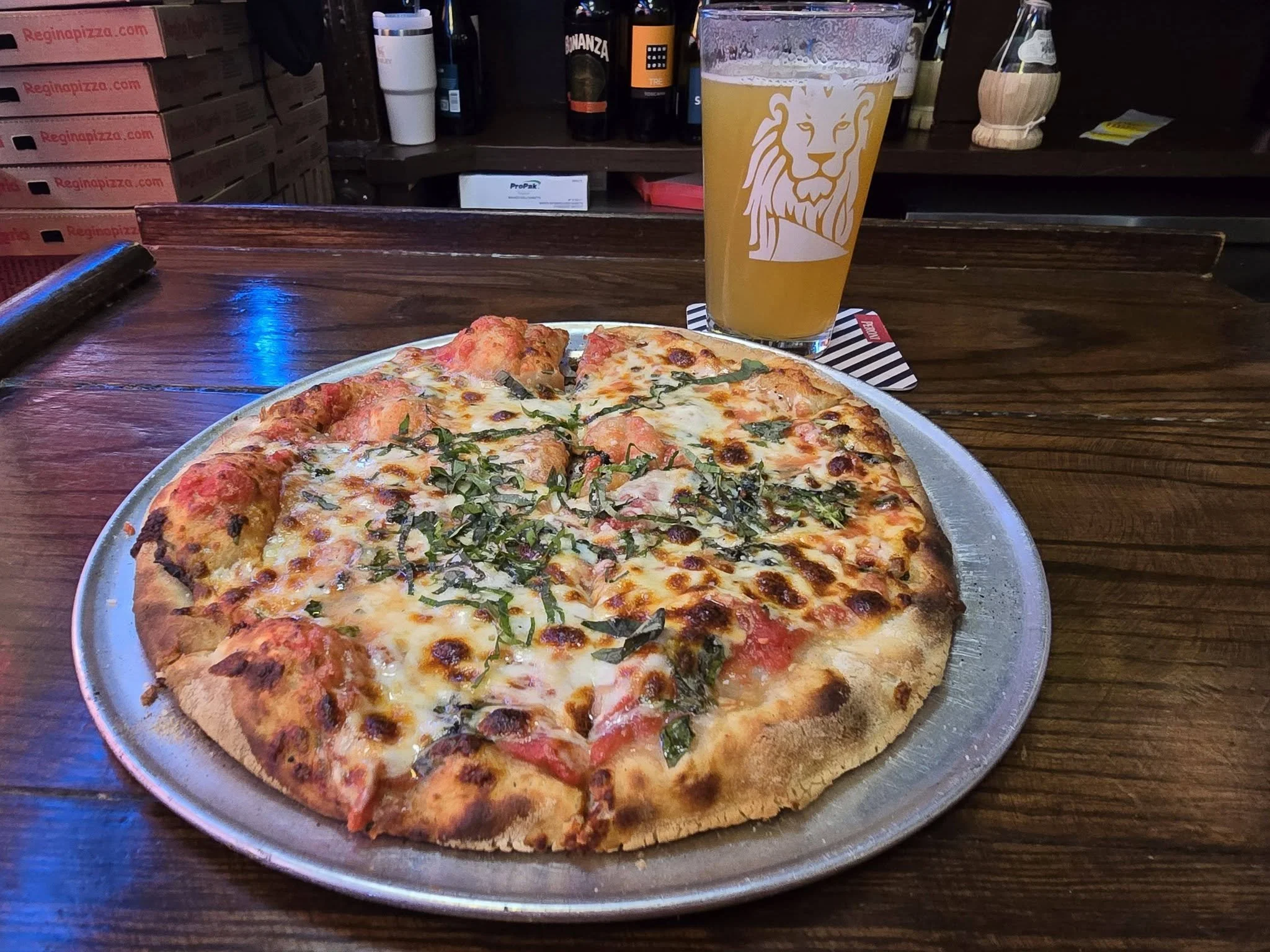 Classic Margherita pizza and a cold beer served at the historic Regina Pizzeria in Boston, Massachusetts