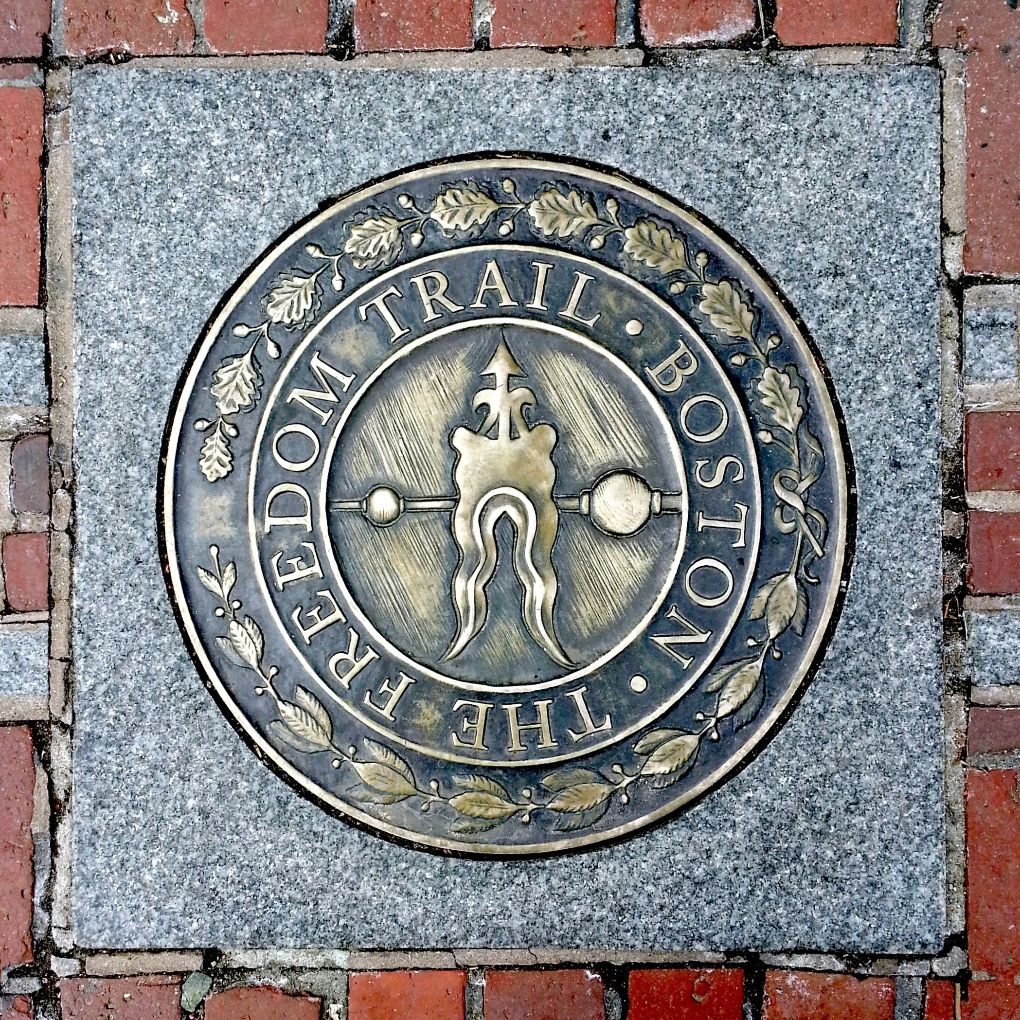 A brass marker embedded in the ground for the Freedom Trail in Boston, Massachusetts