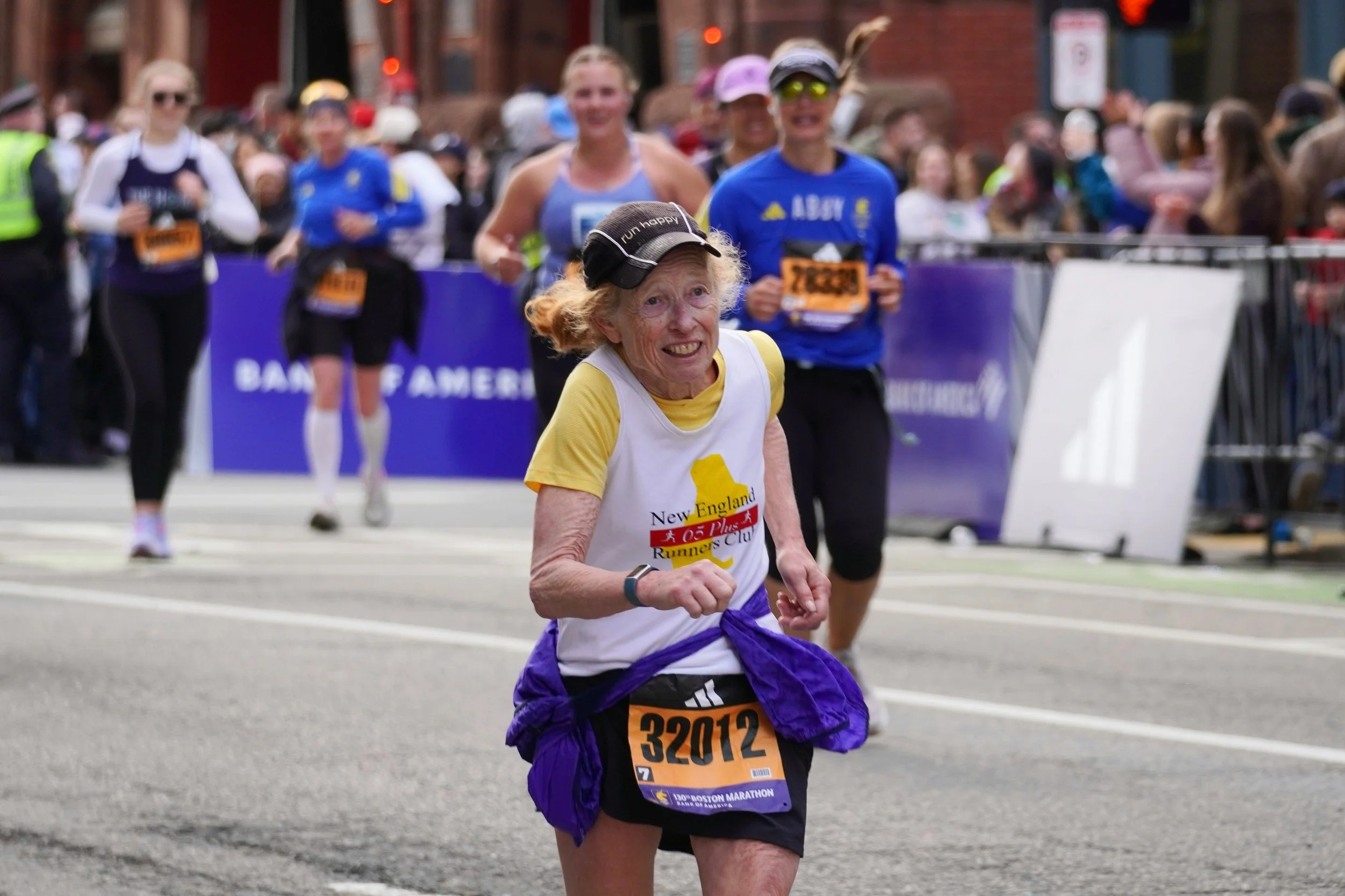 An older participant running in the Boston Marathon wearing bib number 32012.