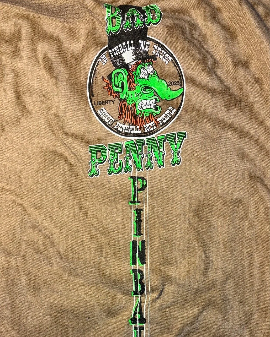 Surprise merch drop for 2026! Oh hi! It's been a while. Still working on finding a new location. In the mean time, enjoy this new shirt.

"Shoot Pinball Not People"

By artist Doug Mac of Art for Sickos.

$20 in stock and ready to ship on w