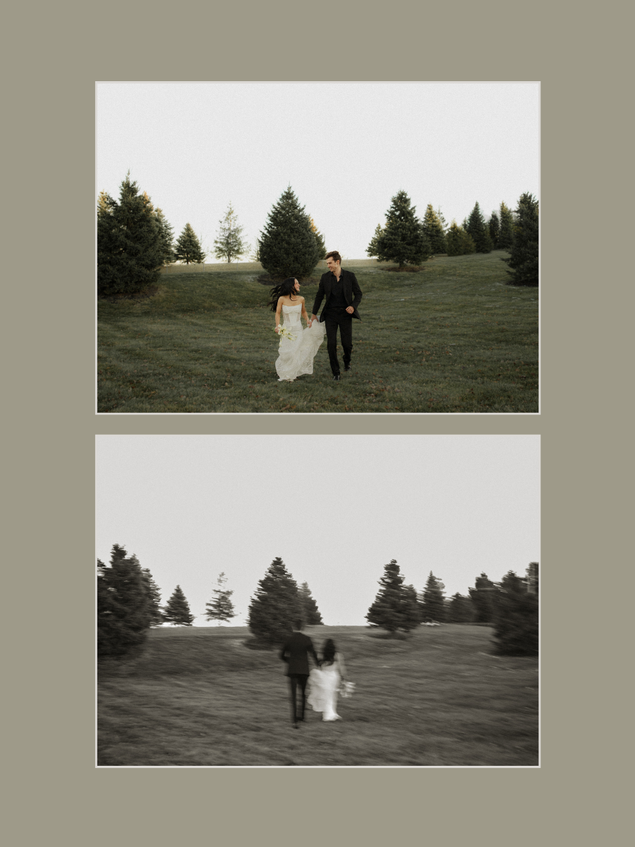 A couple walking through a grassy field with pine trees in the background, the woman in a wedding dress holding a bouquet, and the man in a black suit.