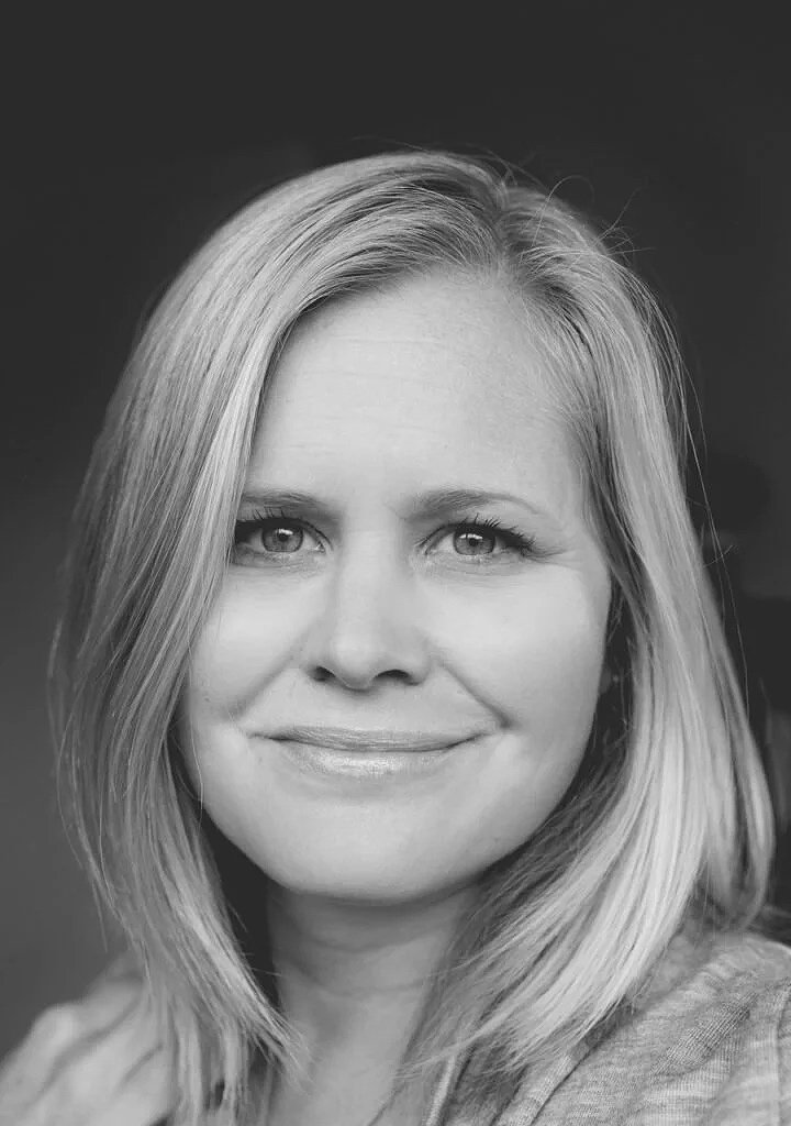 Black and white portrait of a smiling woman with shoulder-length hair.