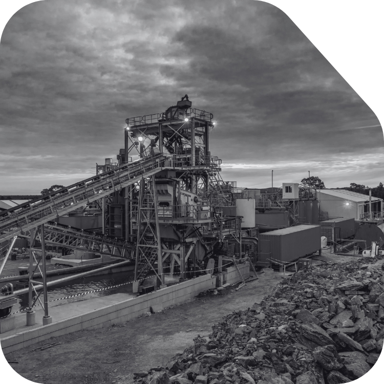 Industrial factory or plant with large machinery, conveyor belts, and structures under a cloudy sky