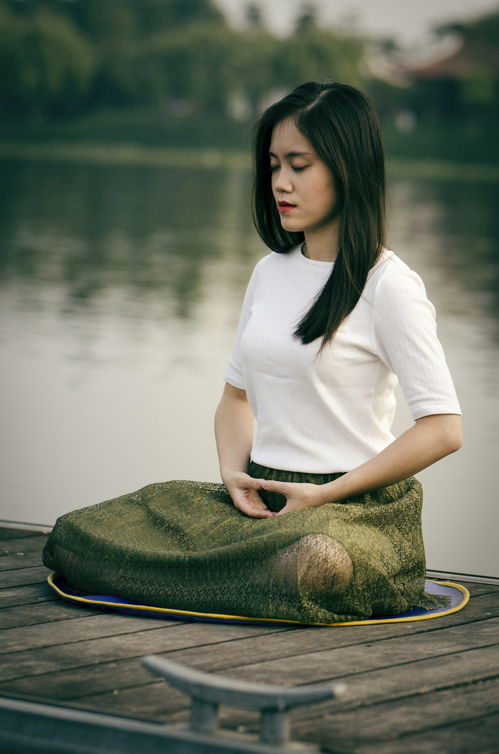 woman meditating by the water integrating mind and body
