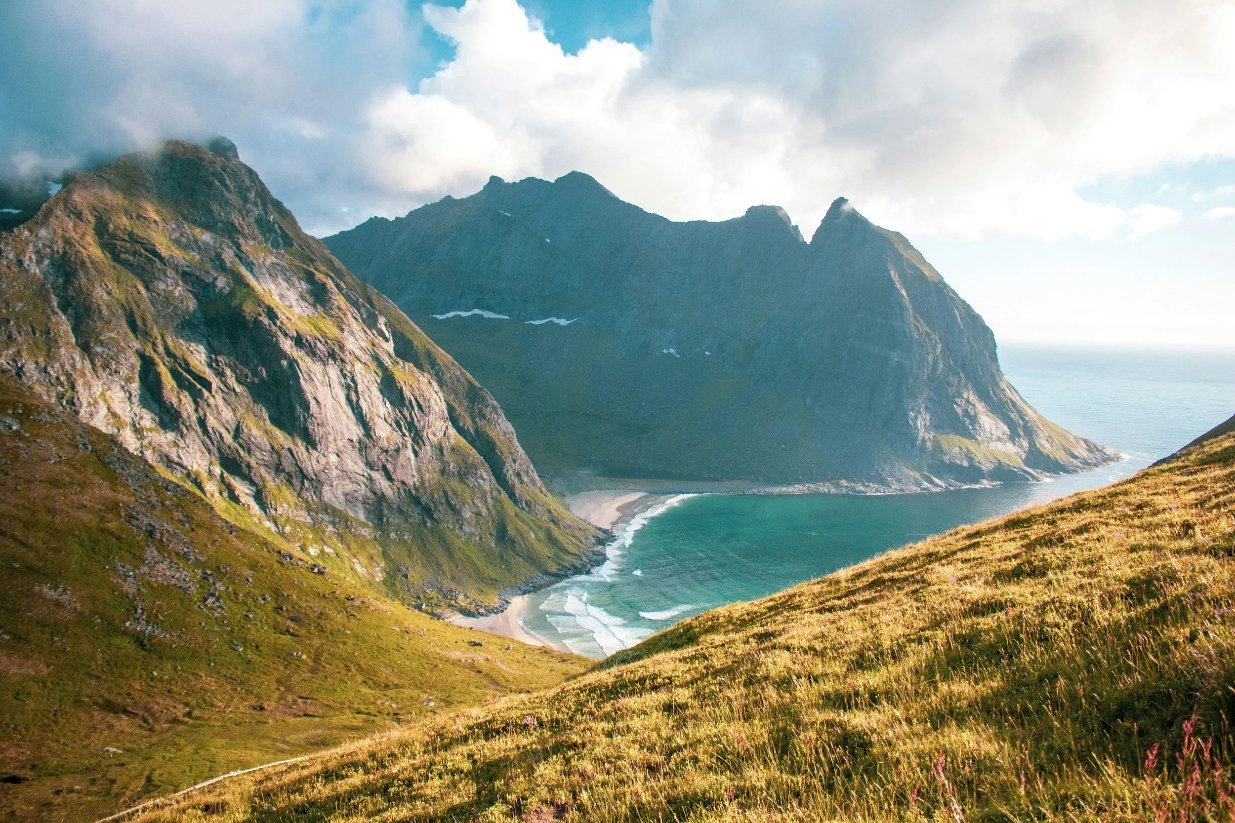 Berglandschaft mit steilen Klippen, Strand und Meer, bei Sonnenlicht