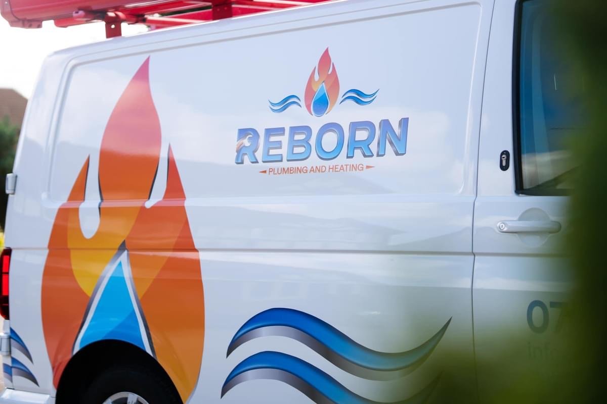 A white service van with a logo for 'Reborn Plumbing and Heating,' featuring a stylized flame and water drop, along with flame and water wave graphics.