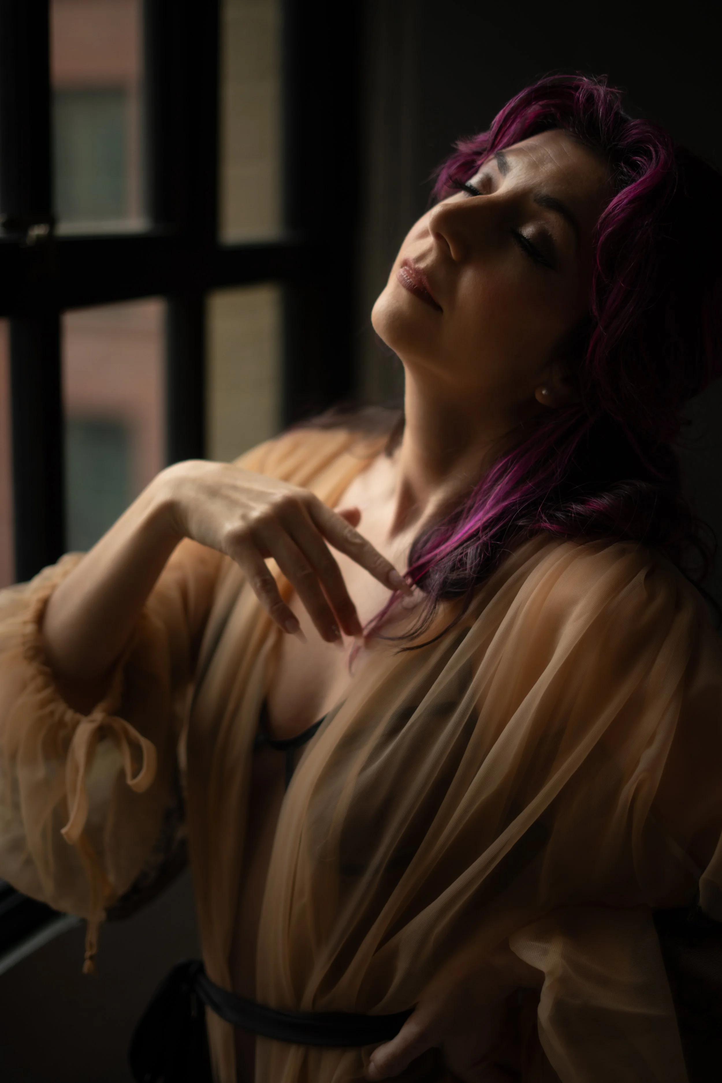 An alternative woman with purple hair in a vintage boudoir robe.