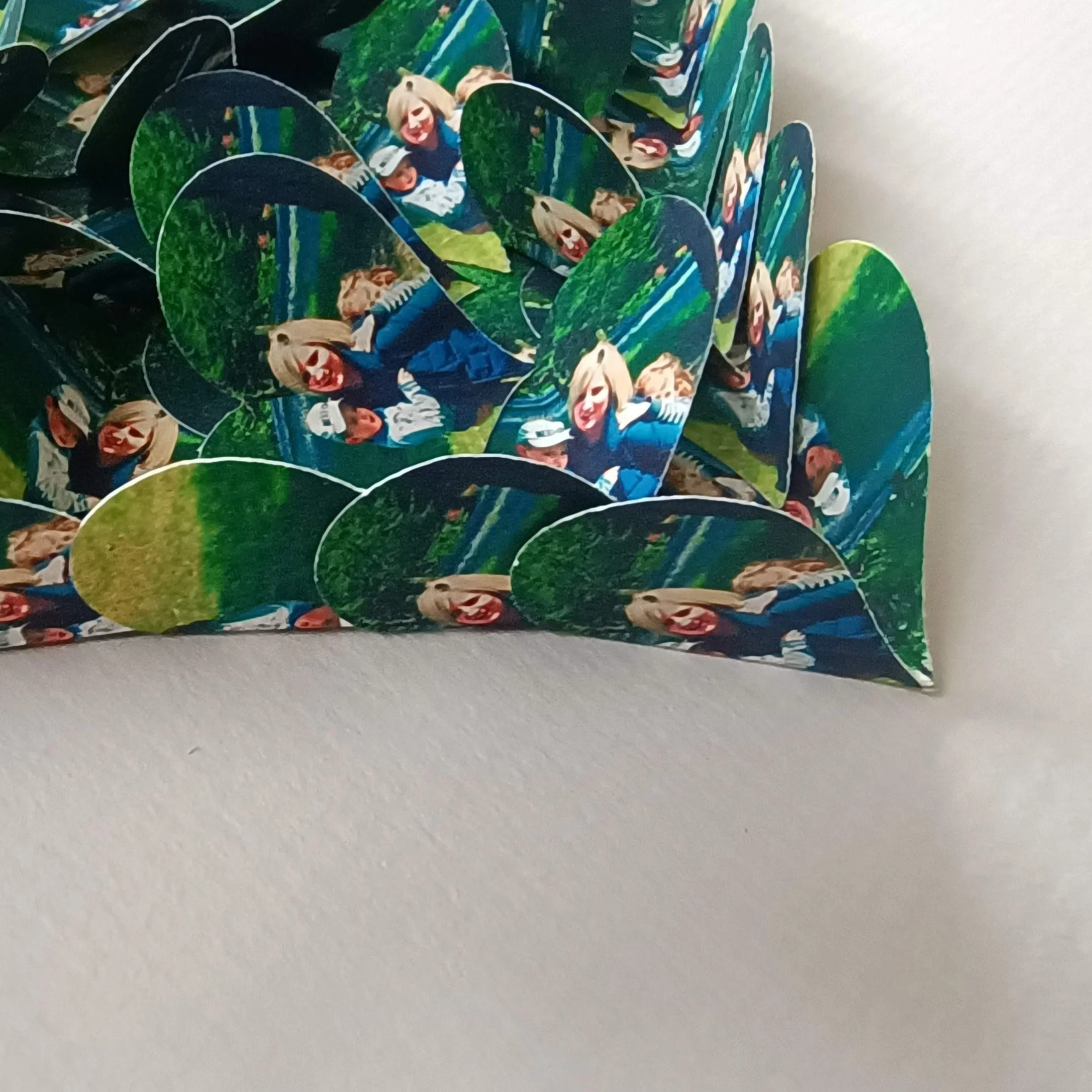 Close-up of layered hearts with a photo of three people outdoors, smiling, on a green grassy background.