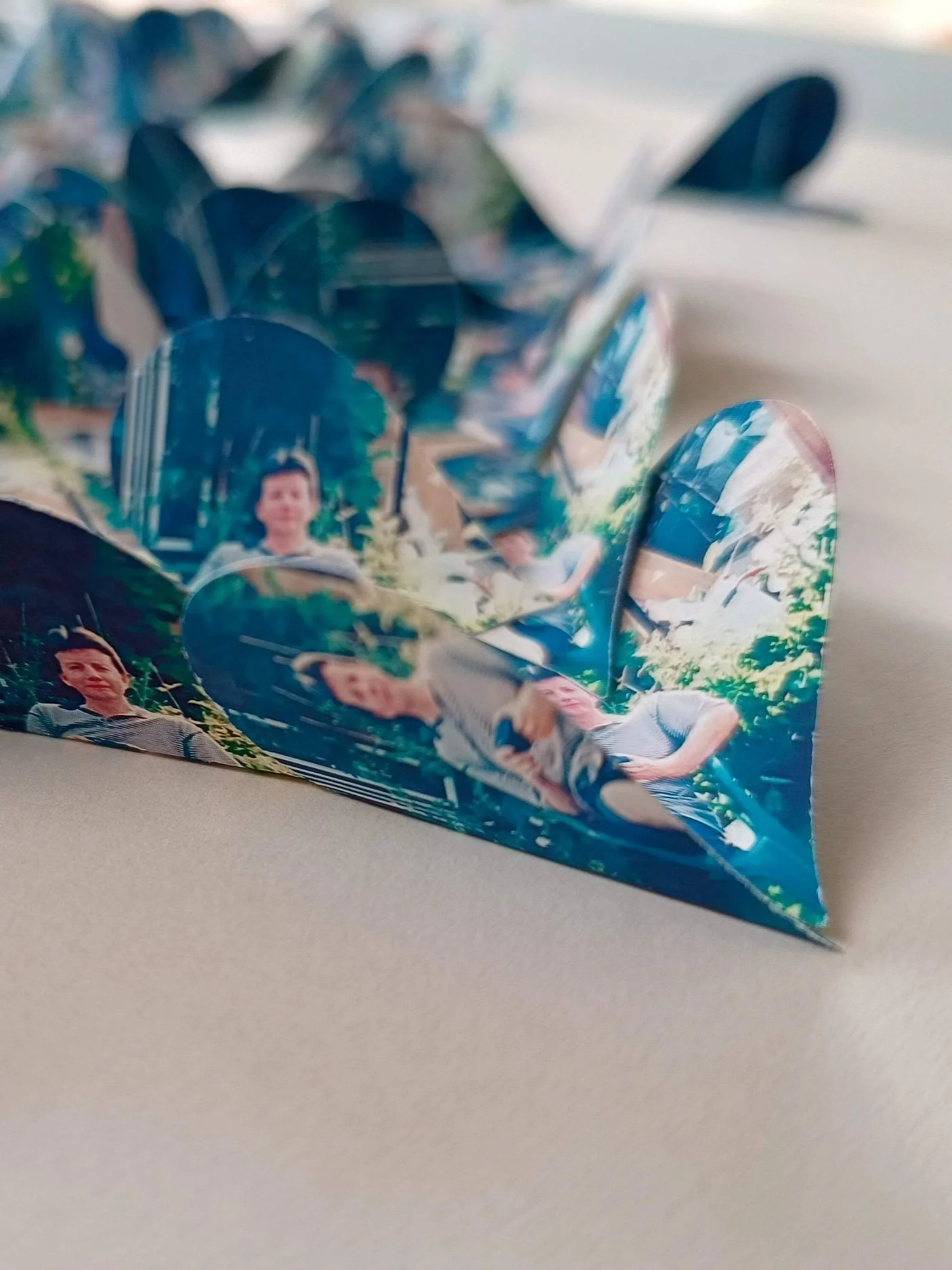 Close-up of a photo collage with multiple pictures, attached to a paper background.