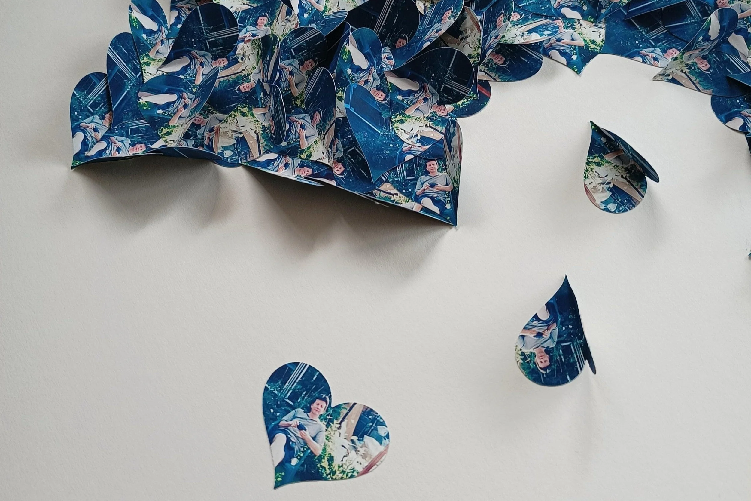 Decorative paper hearts printed photo of a man sitting outdoors