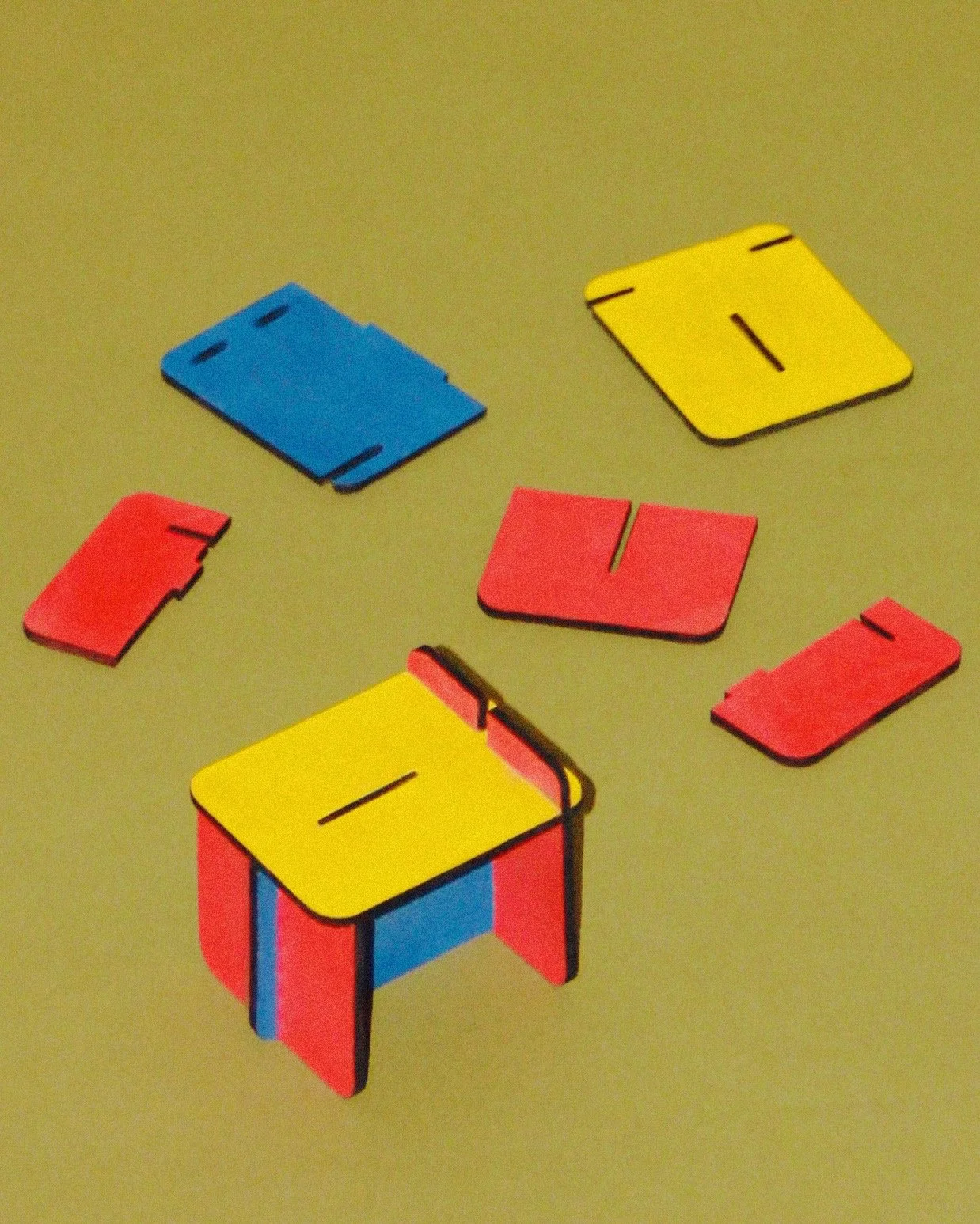 Colorful plastic educational matching game pieces, including blue, yellow, and red shapes, on a green surface.