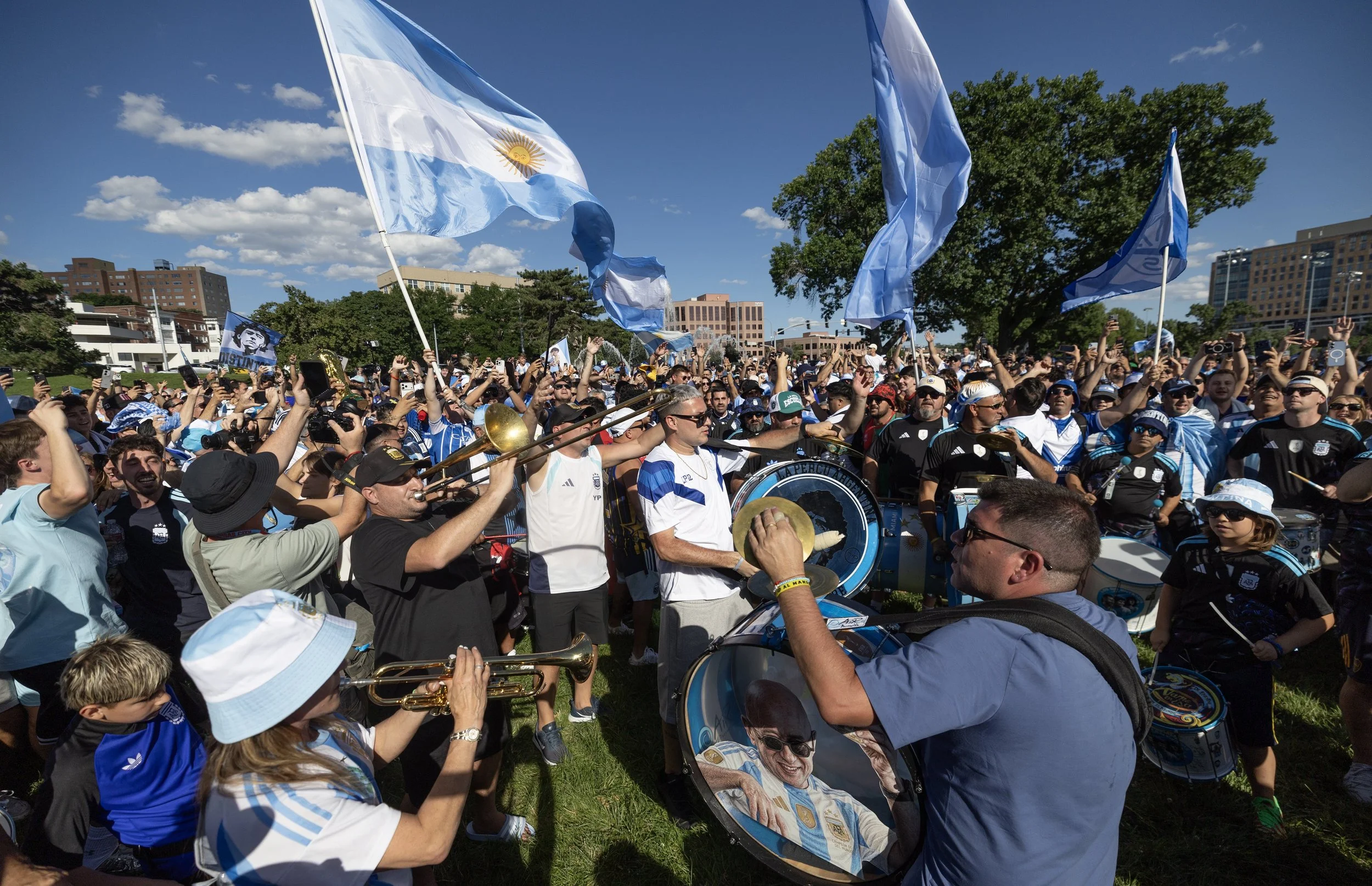 Fans wave a large Argentina flag and play instruments