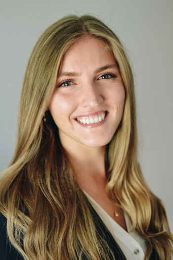 A woman with long blonde hair smiling at the camera.
