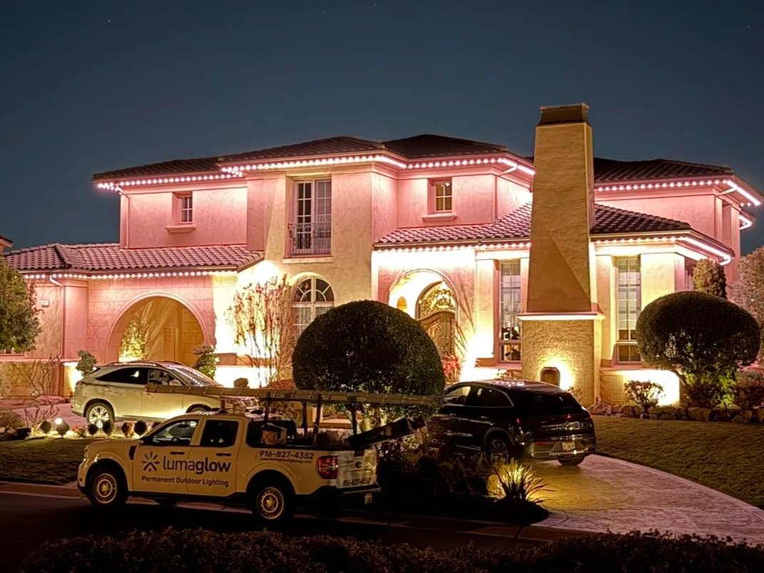 Two-story home in El Dorado Hills featuring JellyFish permanent holiday lighting along the roofline at night.