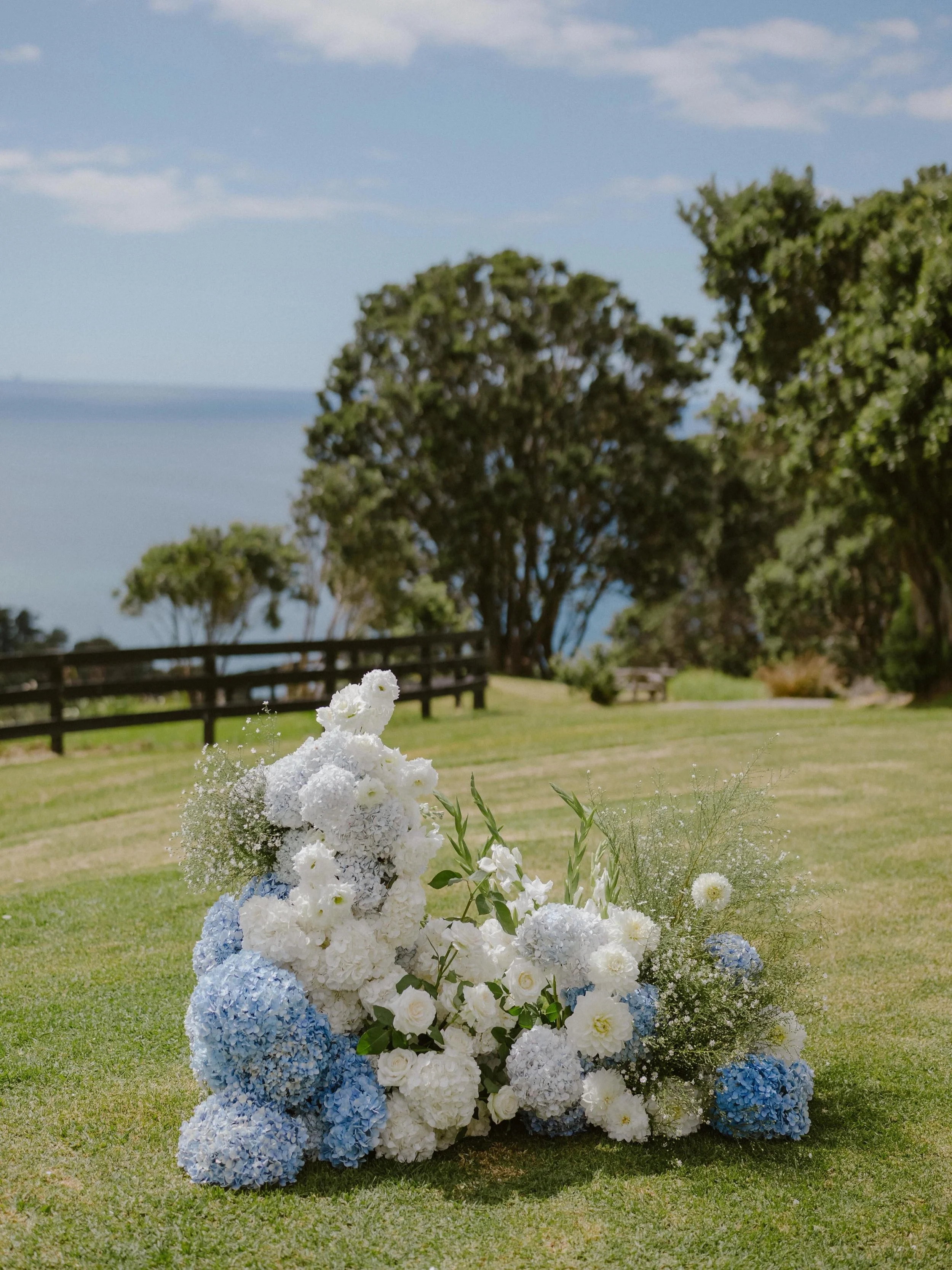 These lush floral arrangements by @asterandbloom gave a luxe coastal feel to S&amp;D&rsquo;s seaside day! 🐚🤍 

We are obsessed with the soft blues, dreamy creams, and organic textures that blended so beautifully with the natural ceremony backdrop a
