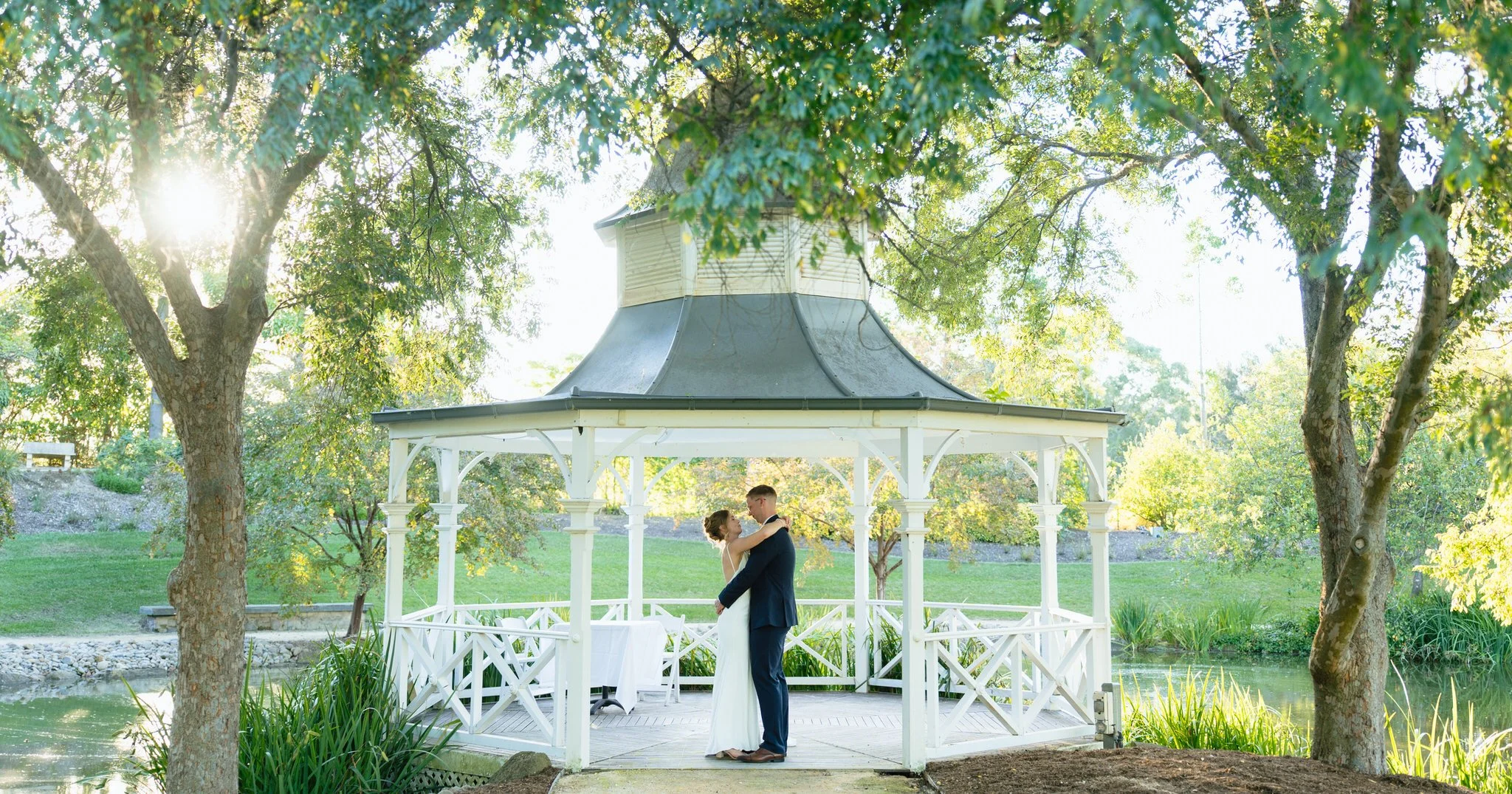 Couple hugging gazebo Hunter Valley Gardens sunset portrait