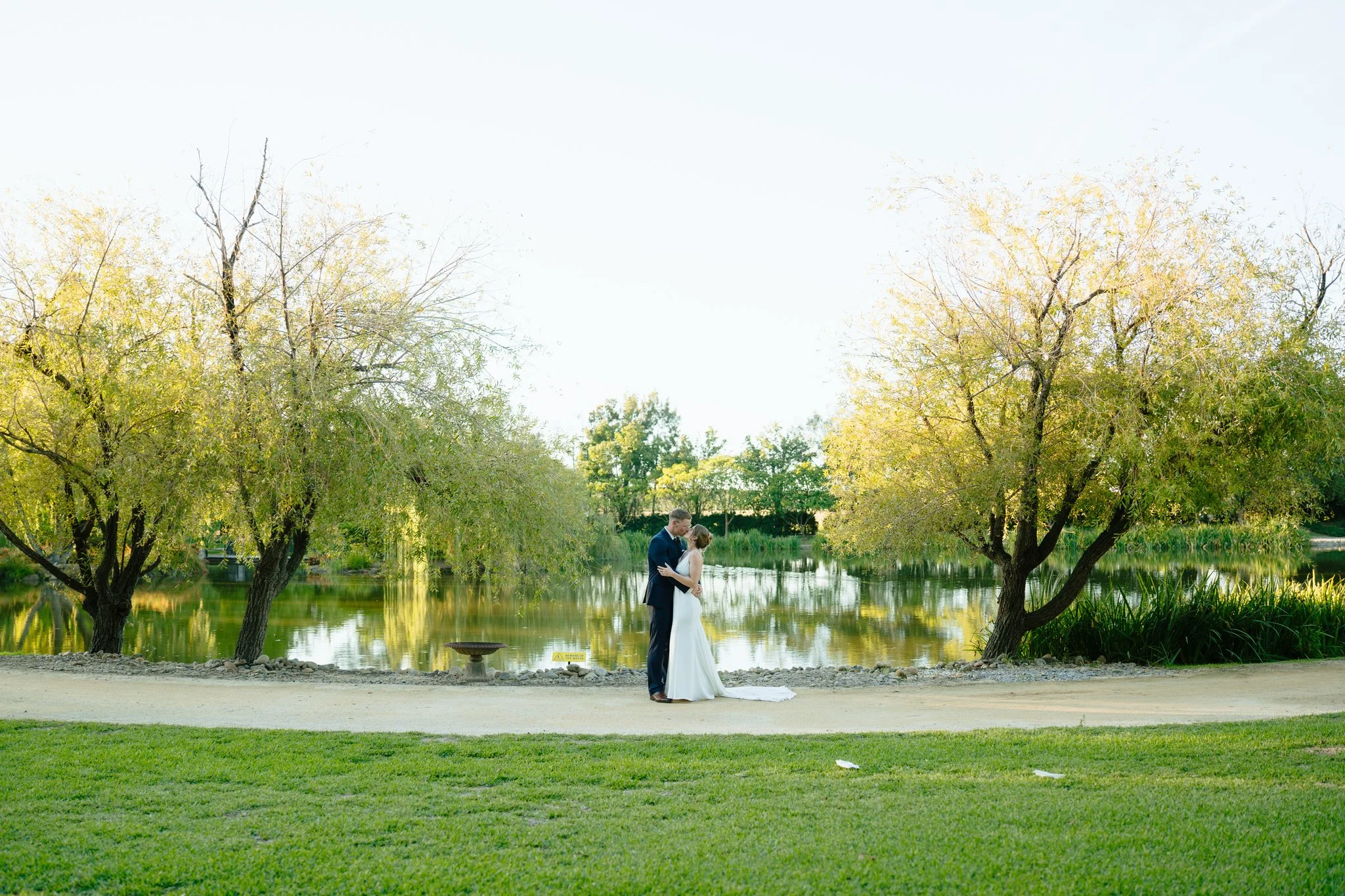 Couple embracing by a lake at Hunter Valley Gardens engagement or wedding photo session in Pokolbin NSW