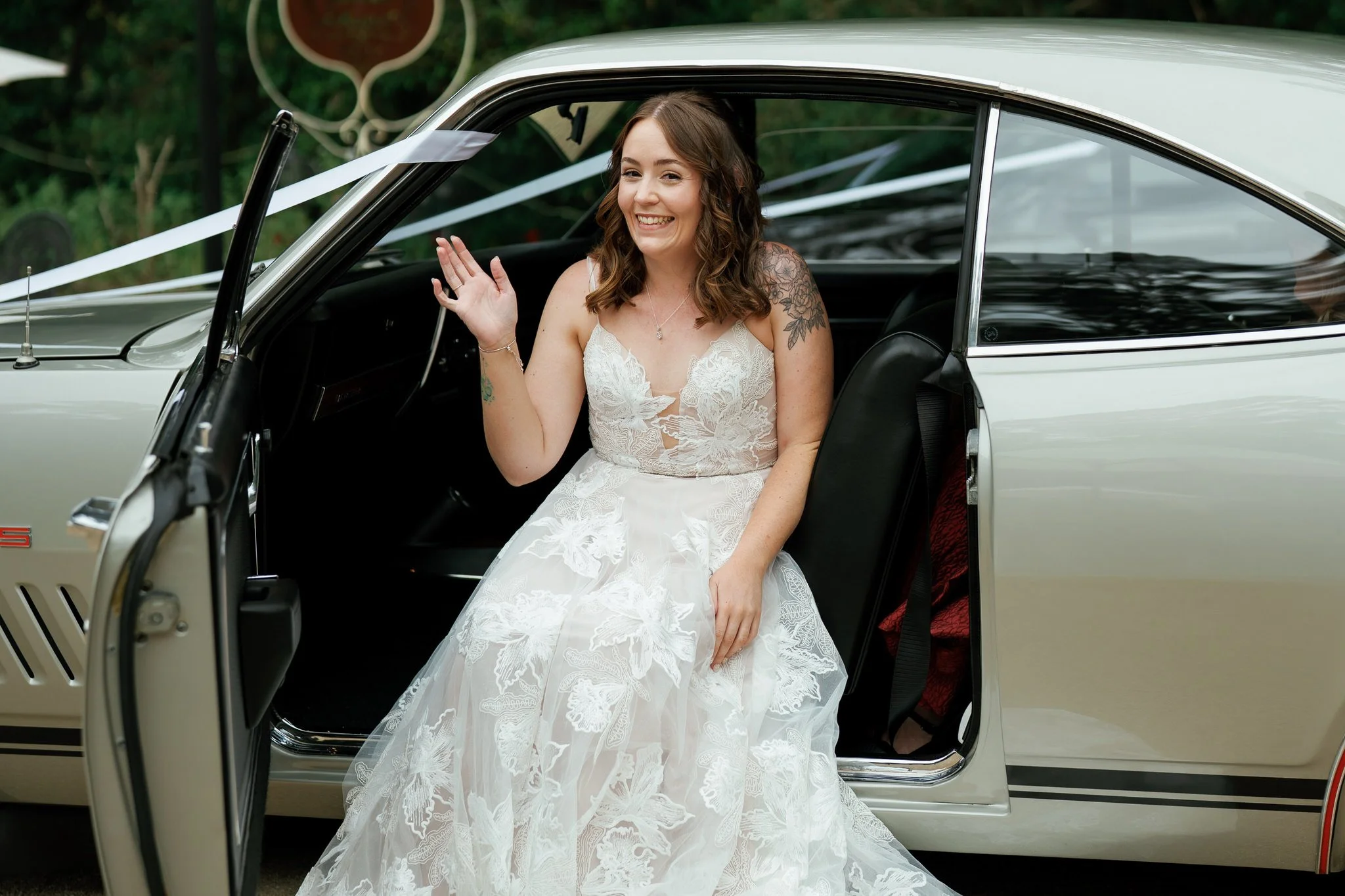 Smiling Bride Waving from Holden Wedding Car at Kangy Gardens