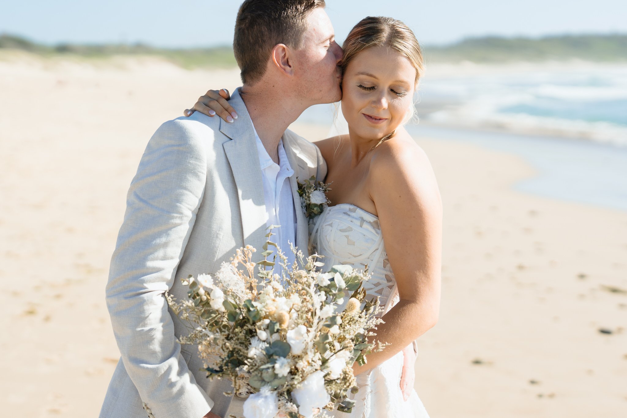 caves-beach-wedding-kiss-portrait
