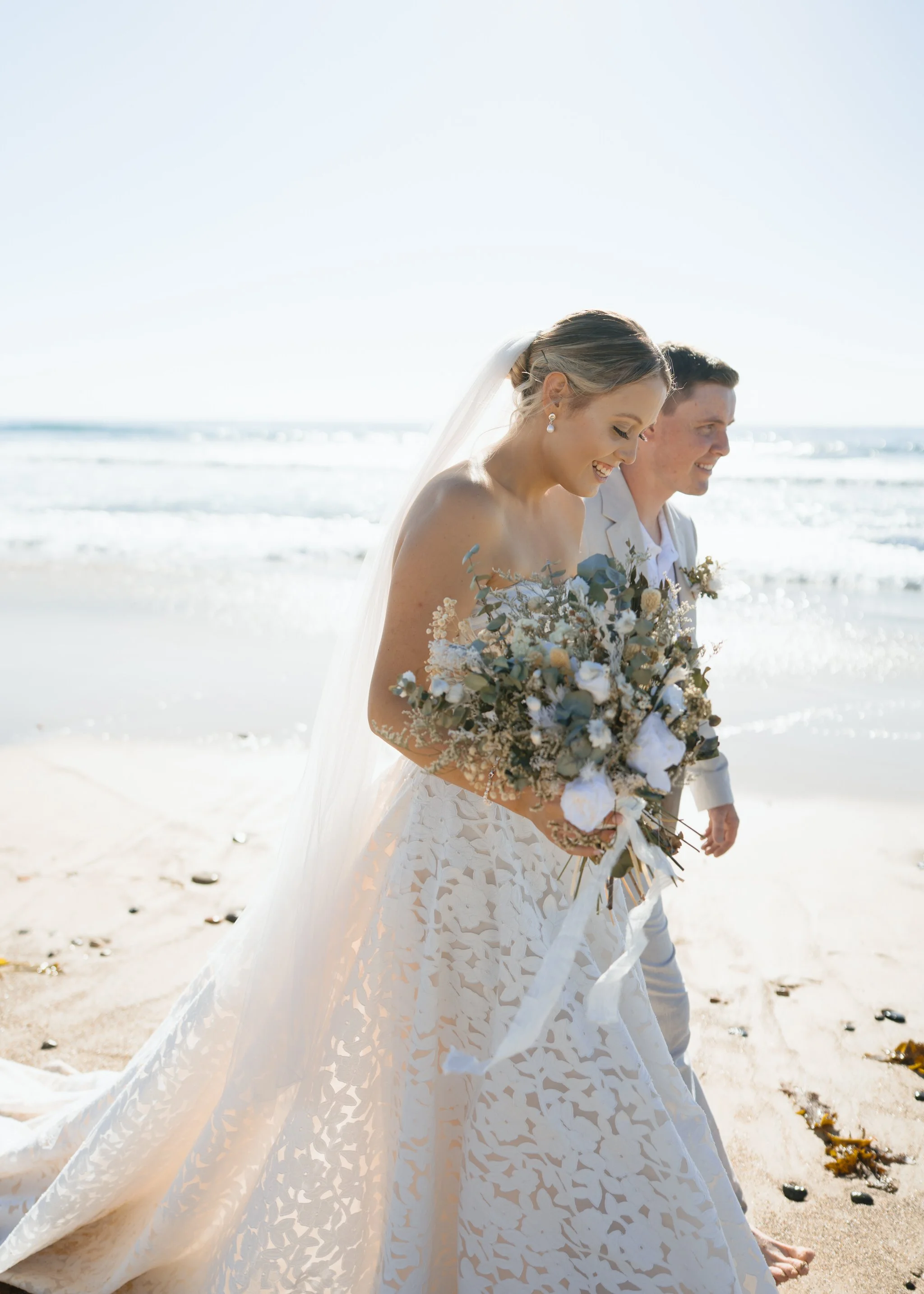 caves-beach-wedding-couple-walking-water-edge