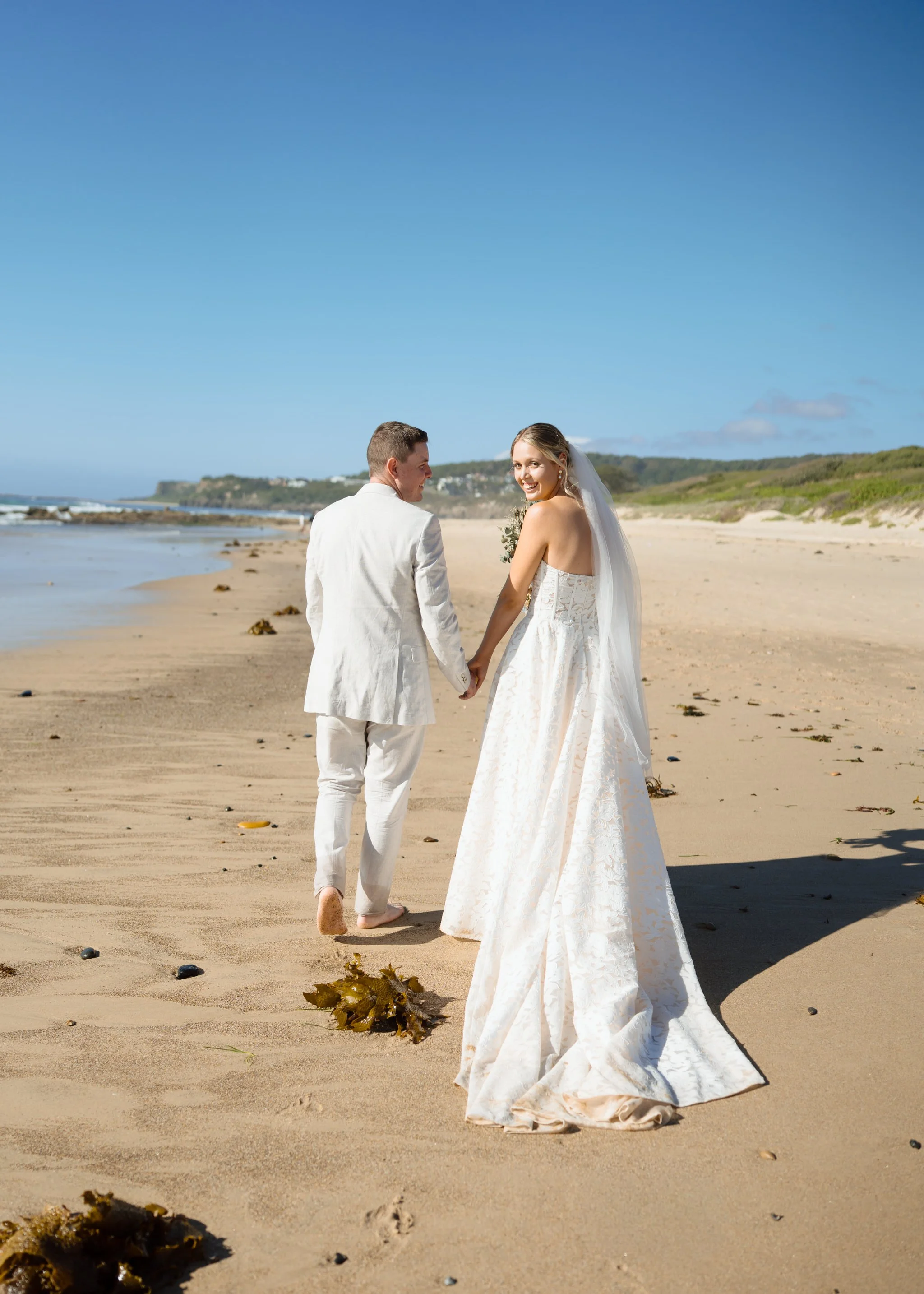 caves-beach-wedding-couple-walking-away