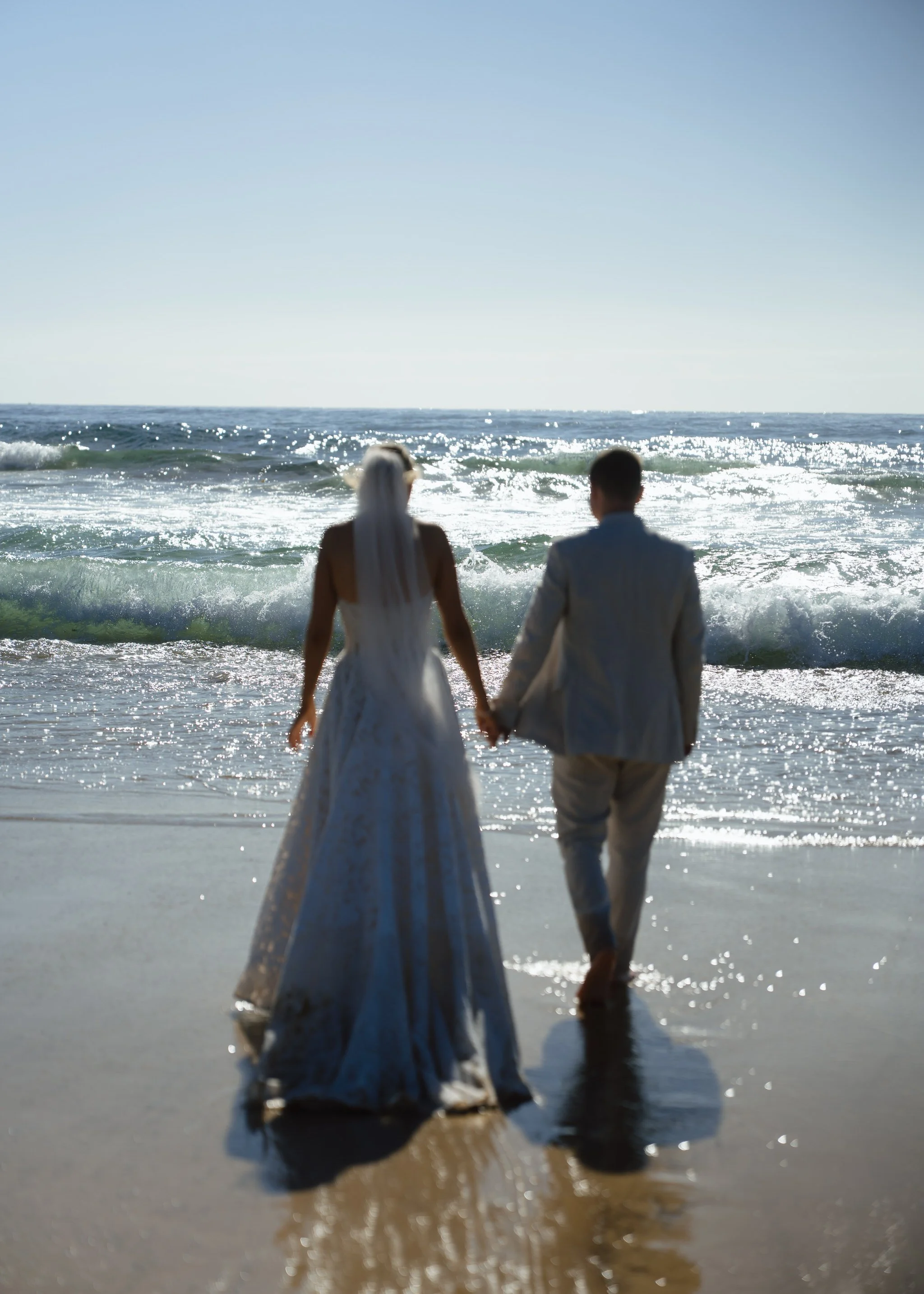 caves-beach-wedding-couple-walking-water-blur