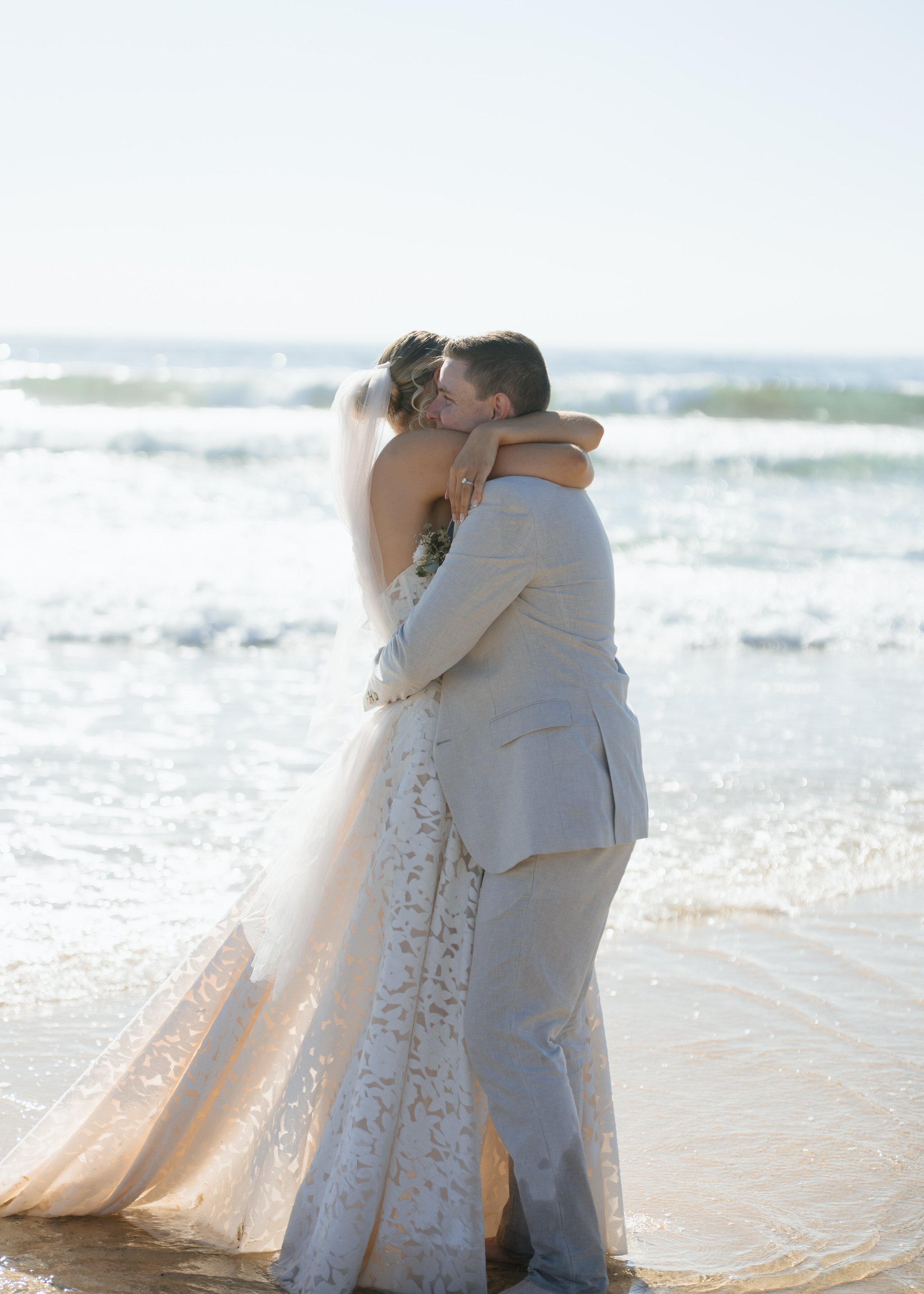 caves-beach-wedding-couple-hug-water