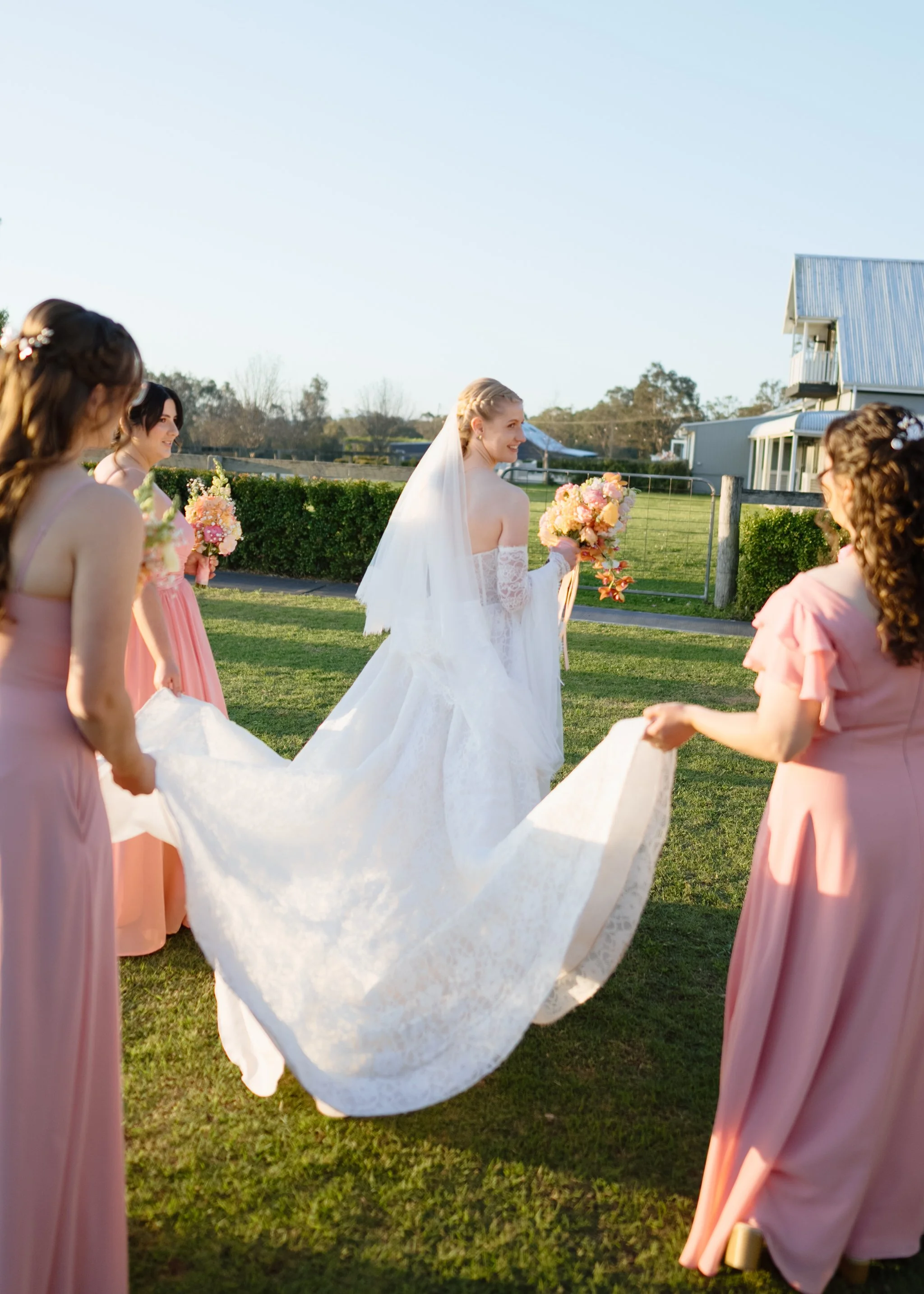 Bridesmaids Helping Carry the Bride's Dress
