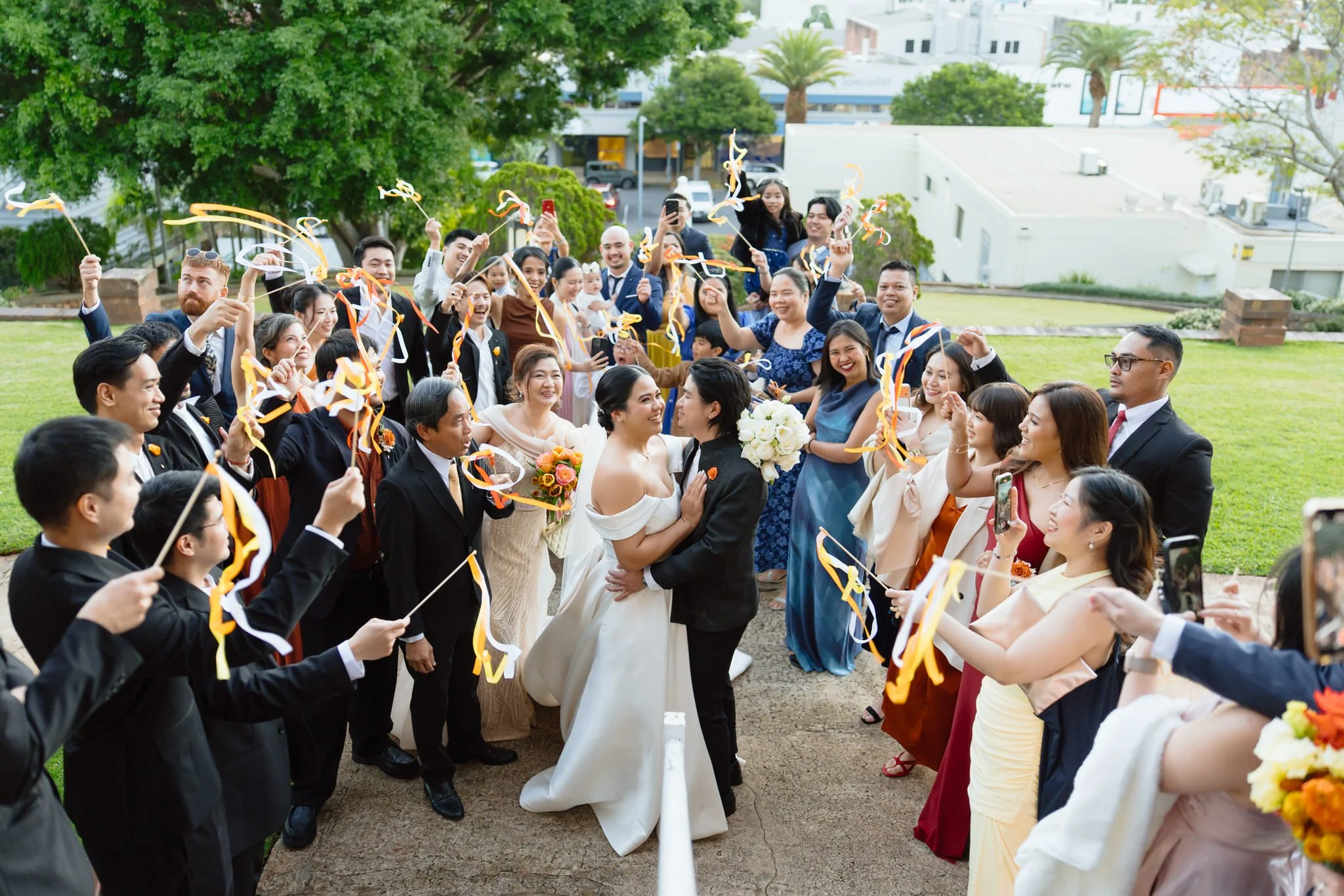Wedding guests celebrating outside St Agnes' Catholic Parish Port Macquarie after the ceremony