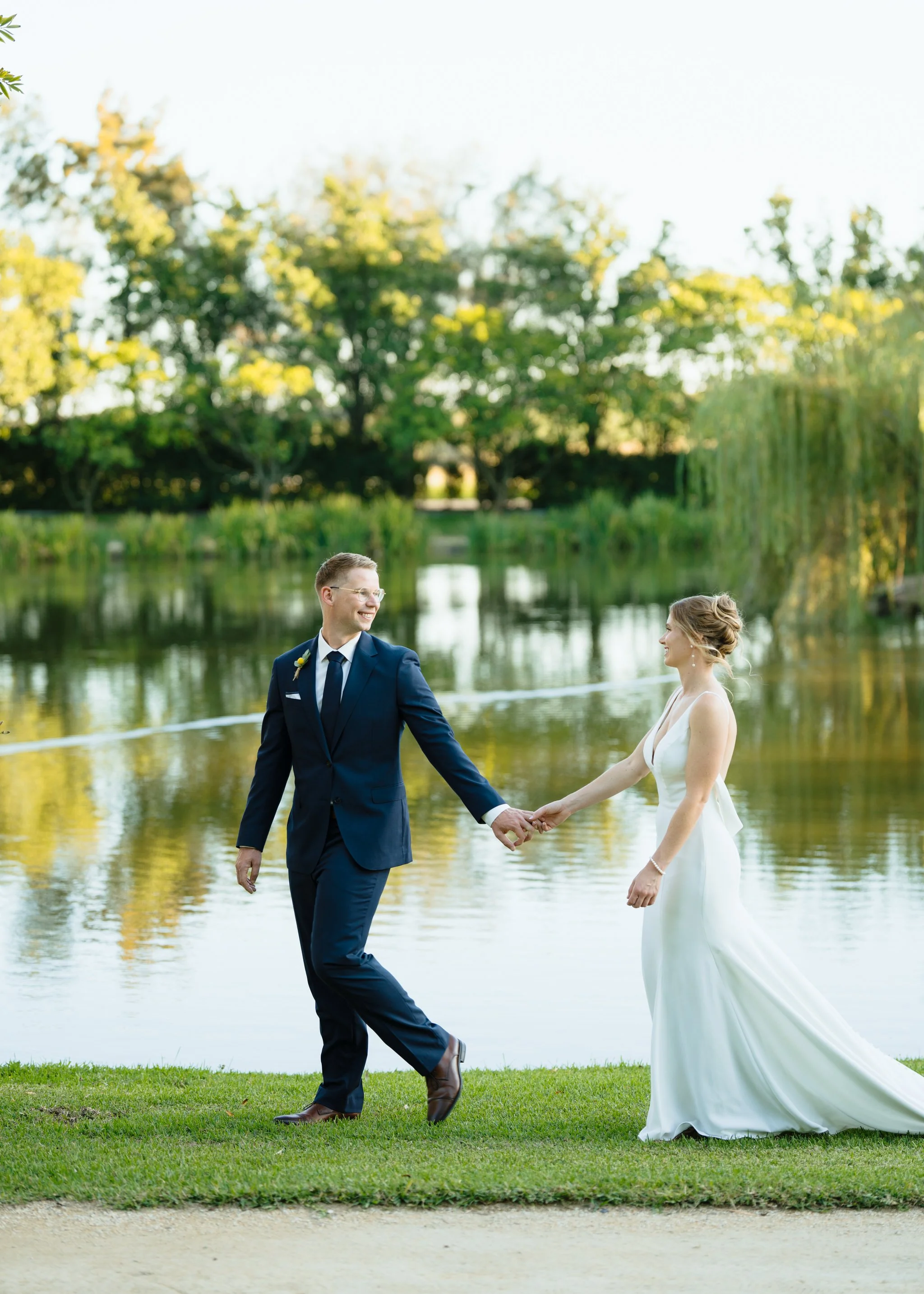 Couple walking by the lake during engagement photo session at Hunter Valley Gardens Pokolbin