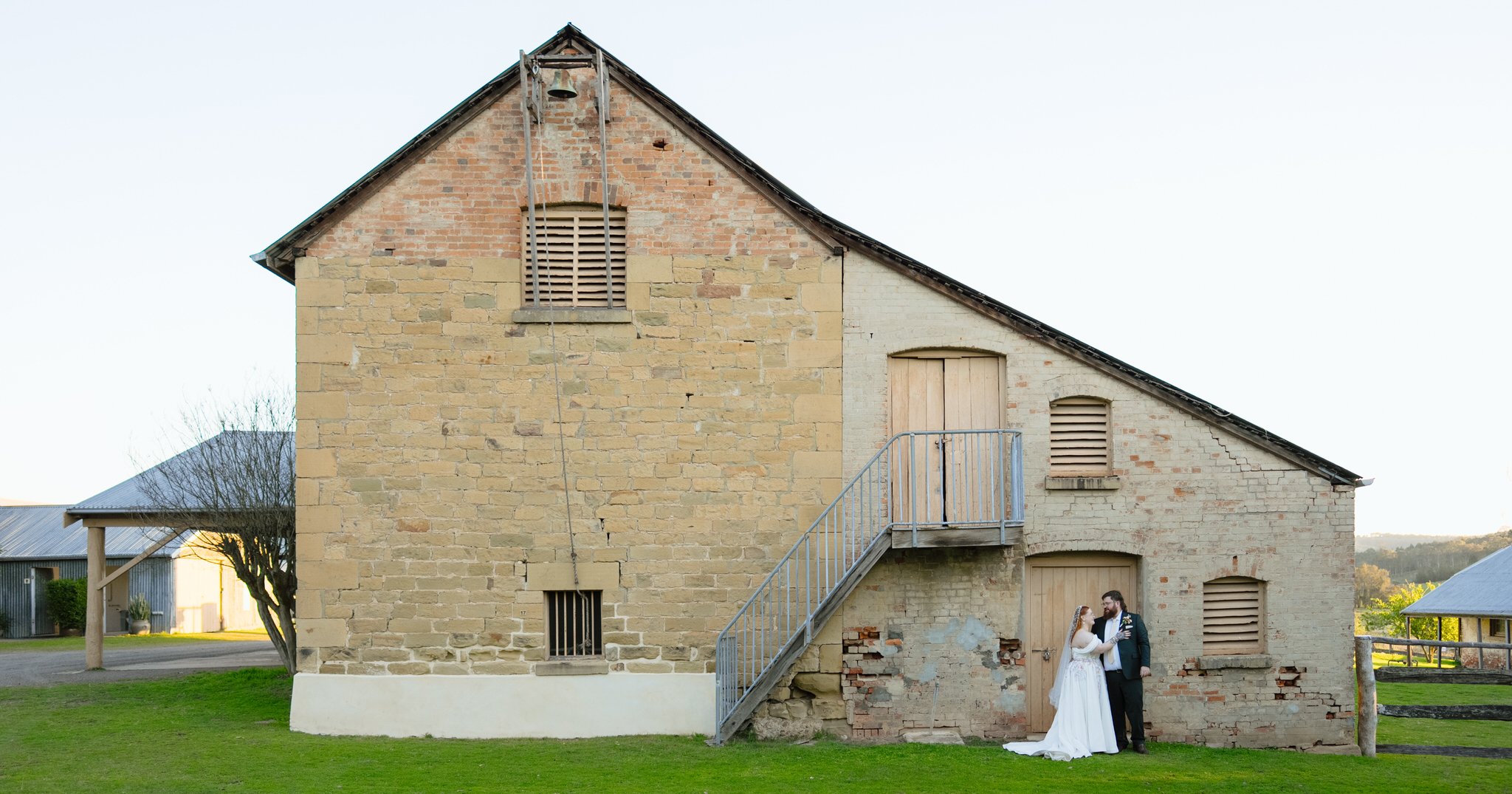 Bride and groom sharing a quiet moment beside the historic sandstone building at Tocal Homestead in Paterson.