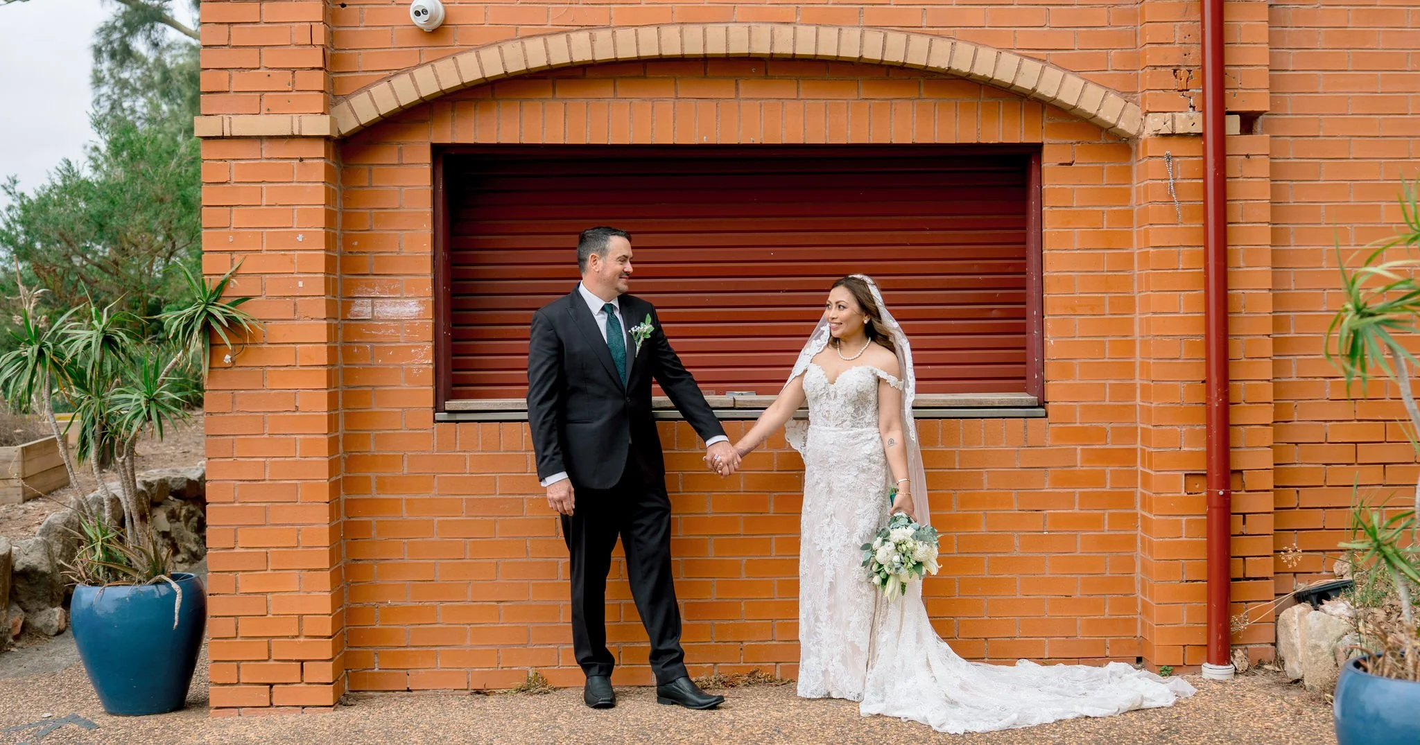 Bride and groom holding hands at Angelo’s Cabarita